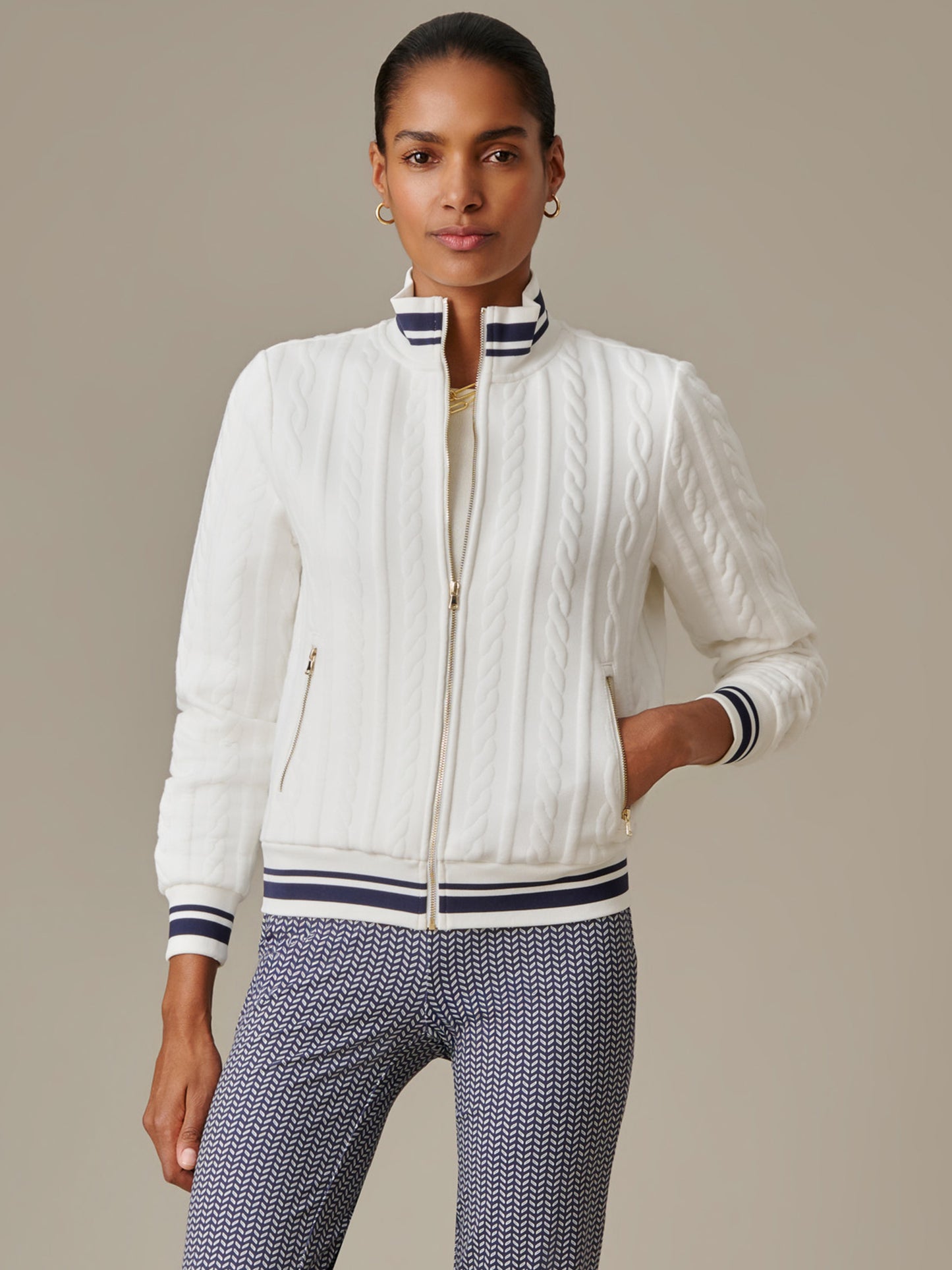 Woman wearing a white Willa Jacket in Cable Jacquard by J.McLaughlin, featuring a textured cable knit pattern with navy striped collar and cuffs, perfect for timeless style.