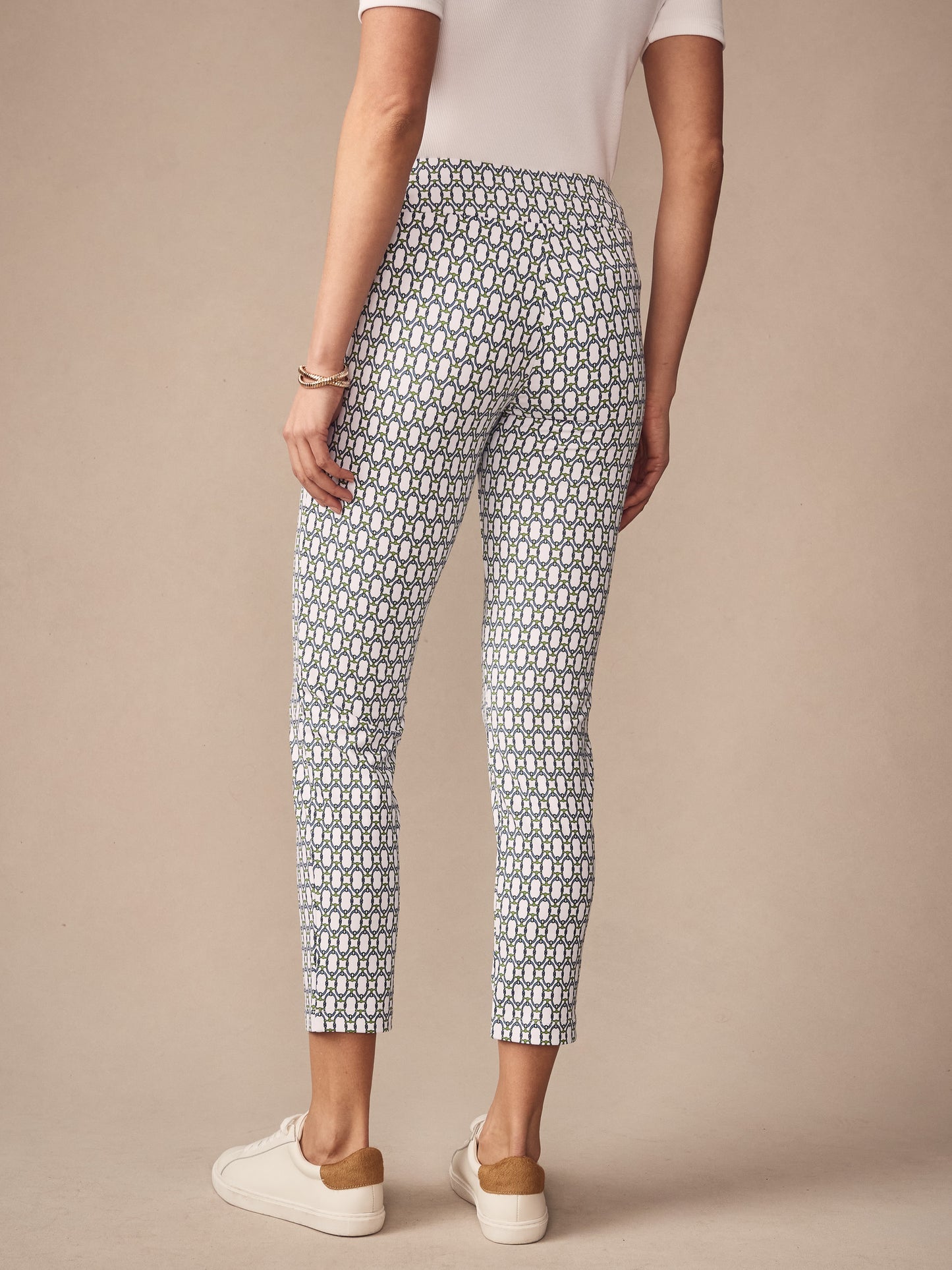 Back view of a woman wearing J.McLaughlin Newport Capri Pants in Signet Lock pattern, styled with a white top and white sneakers, showcasing a timeless and classic look.