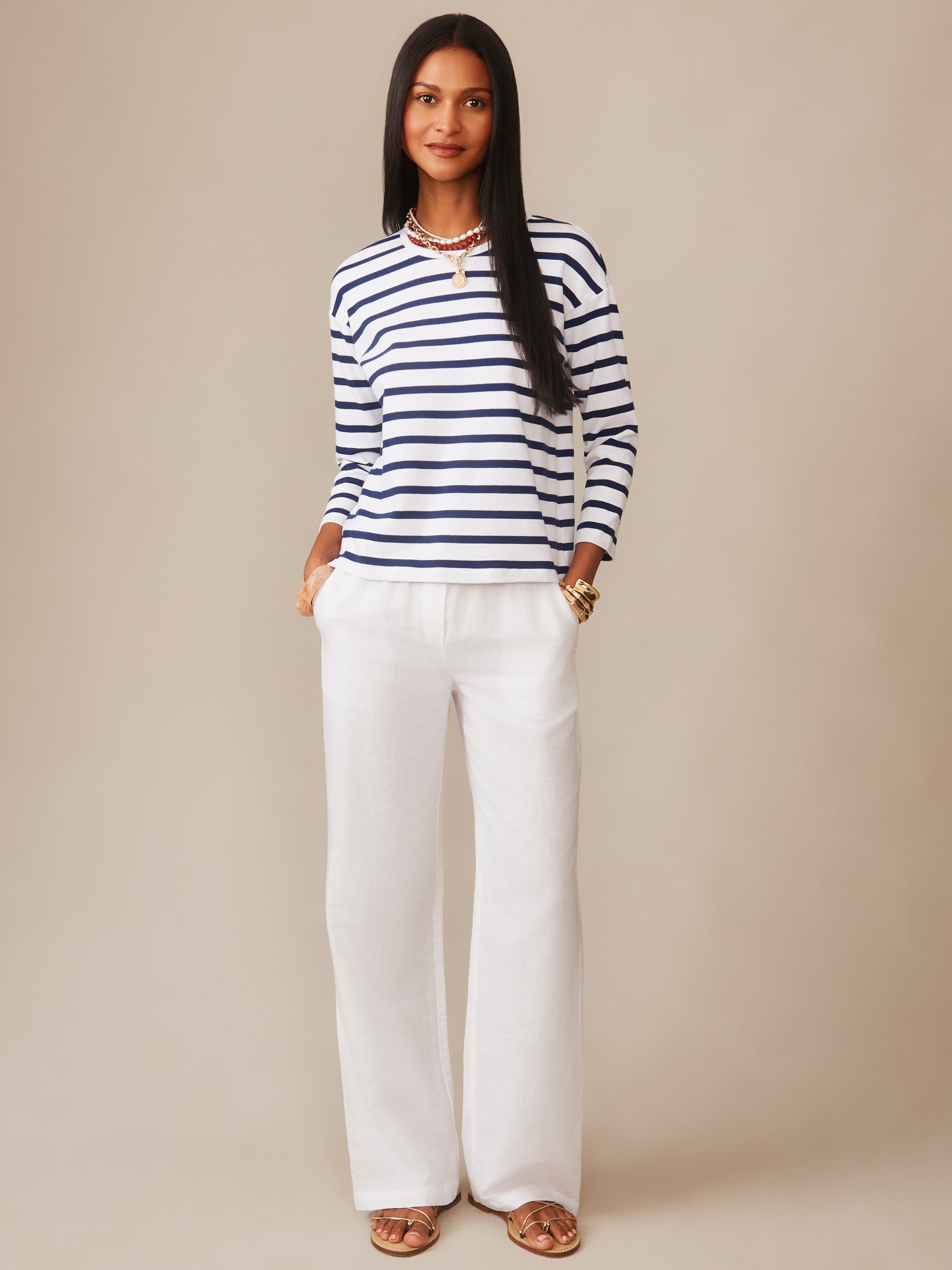 Woman wearing a Nico Tee in Stripe by J.McLaughlin styled with white wide-leg pants, showcasing effortlessly stylish, enduring designs and innovative fabrics for a legacy of timeless fashion. A destination for defining style. Life, Well-Lived.