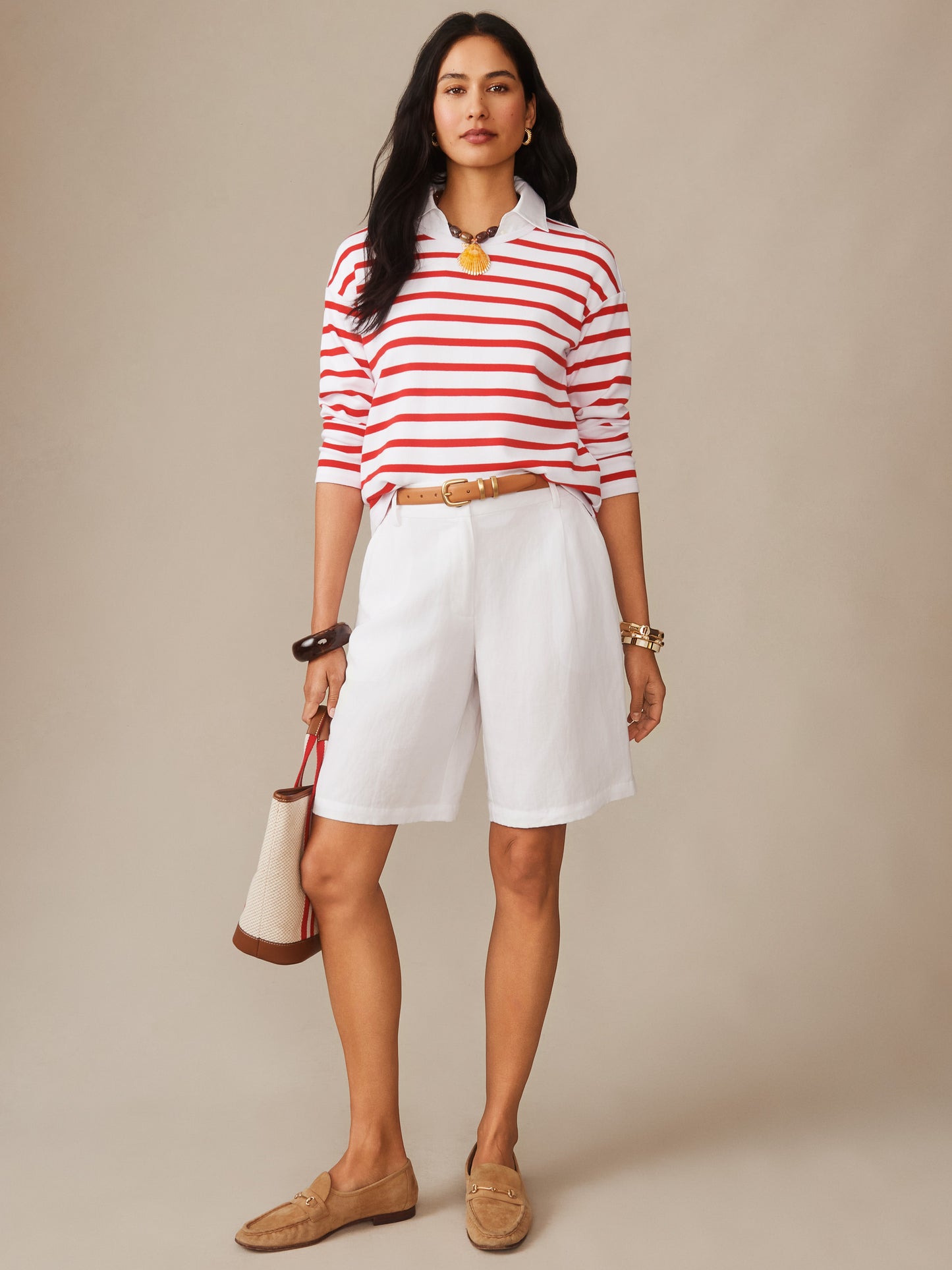 Woman wearing the Nico Tee in Stripe by J.McLaughlin, featuring red and white stripes paired with white shorts, tan belt, and loafers, embodying effortlessly stylish, enduring designs in innovative fabrics for a legacy of timeless fashion. A destination for defining style. Life, Well-Lived.