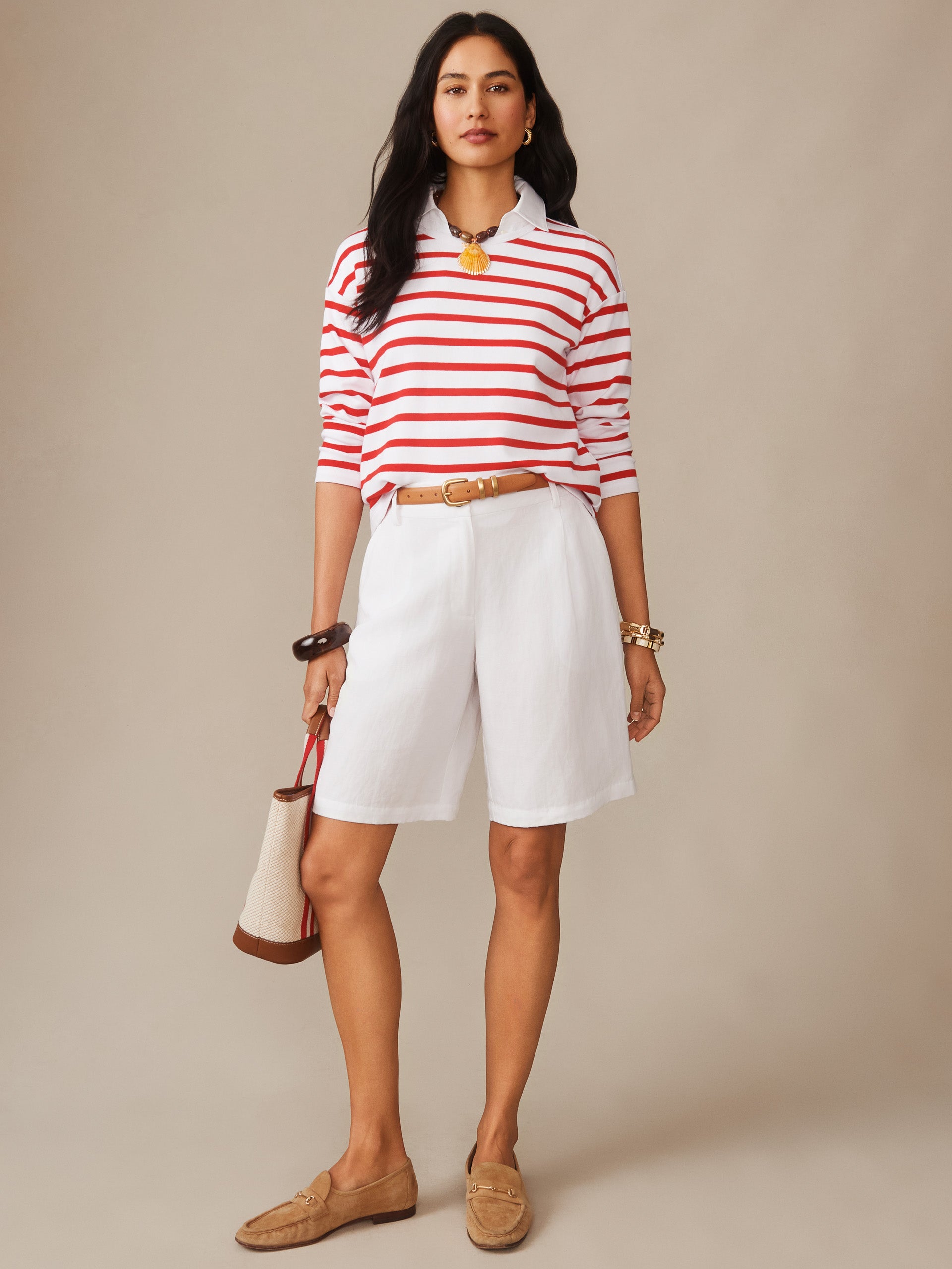 Woman wearing the Nico Tee in Stripe by J.McLaughlin, featuring red and white stripes paired with white shorts, tan belt, and loafers, embodying effortlessly stylish, enduring designs in innovative fabrics for a legacy of timeless fashion. A destination for defining style. Life, Well-Lived.