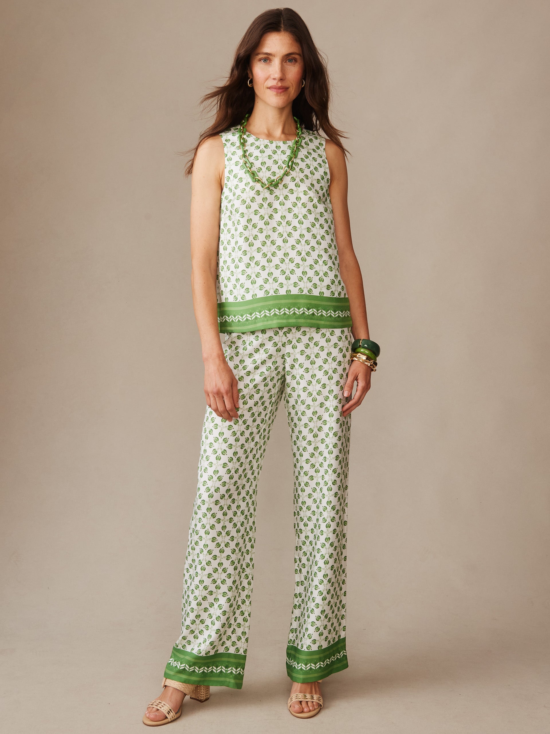 Woman wearing Norie Silk Blend Blouse in Mythic Geo Border by J.McLaughlin, styled with matching pants and green accessories, showcasing effortlessly stylish, enduring designs.