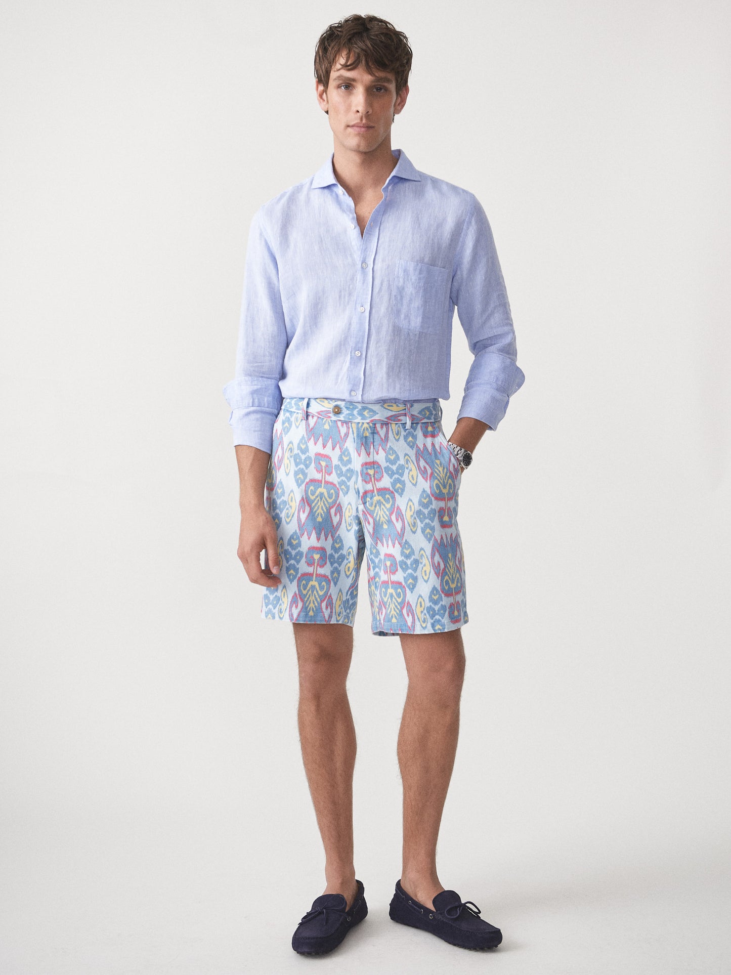 Model wearing J.McLaughlin Oliver shorts in aqua/blue/gold made with cotton.