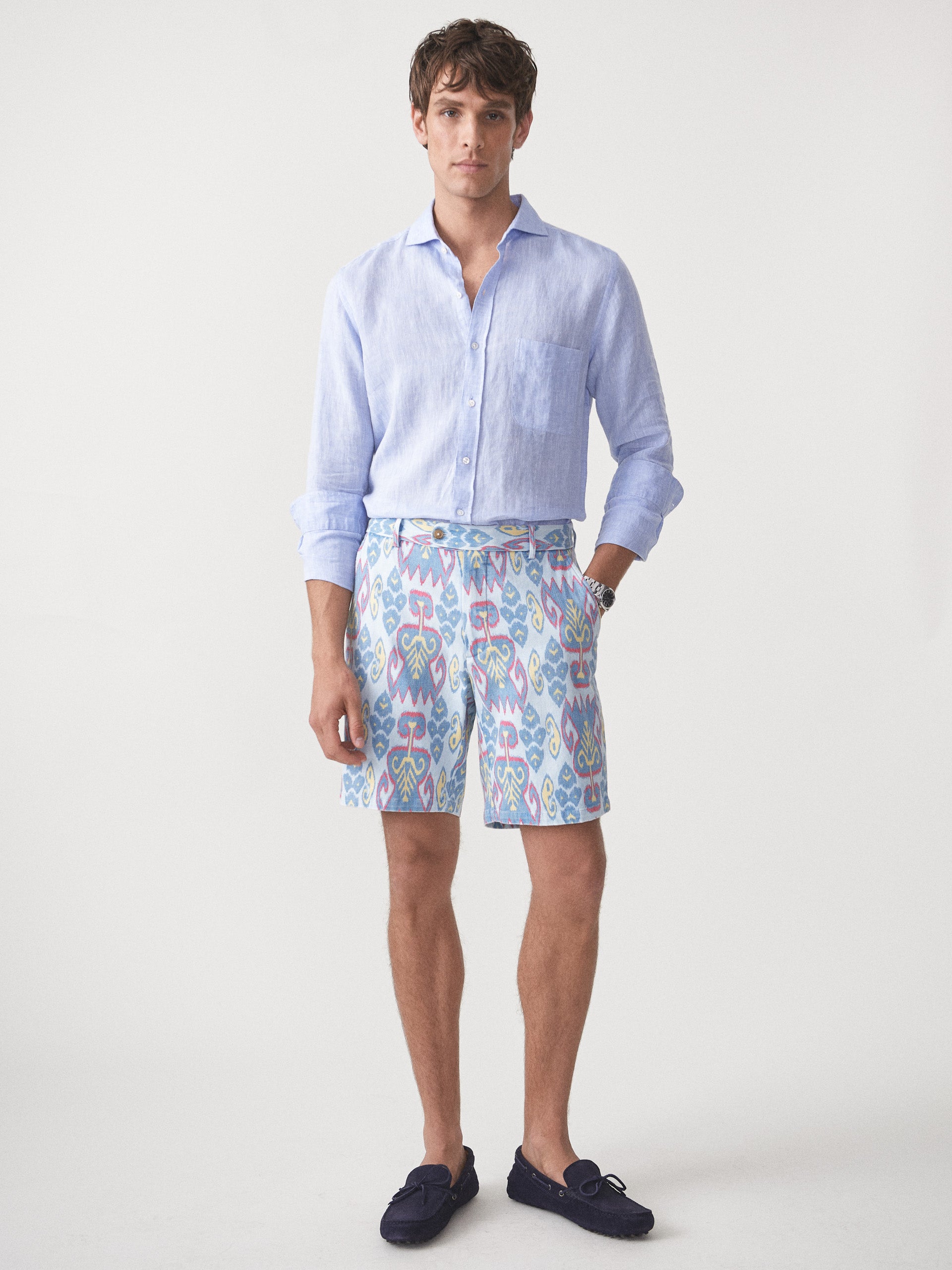 Model wearing J.McLaughlin Oliver shorts in aqua/blue/gold made with cotton.