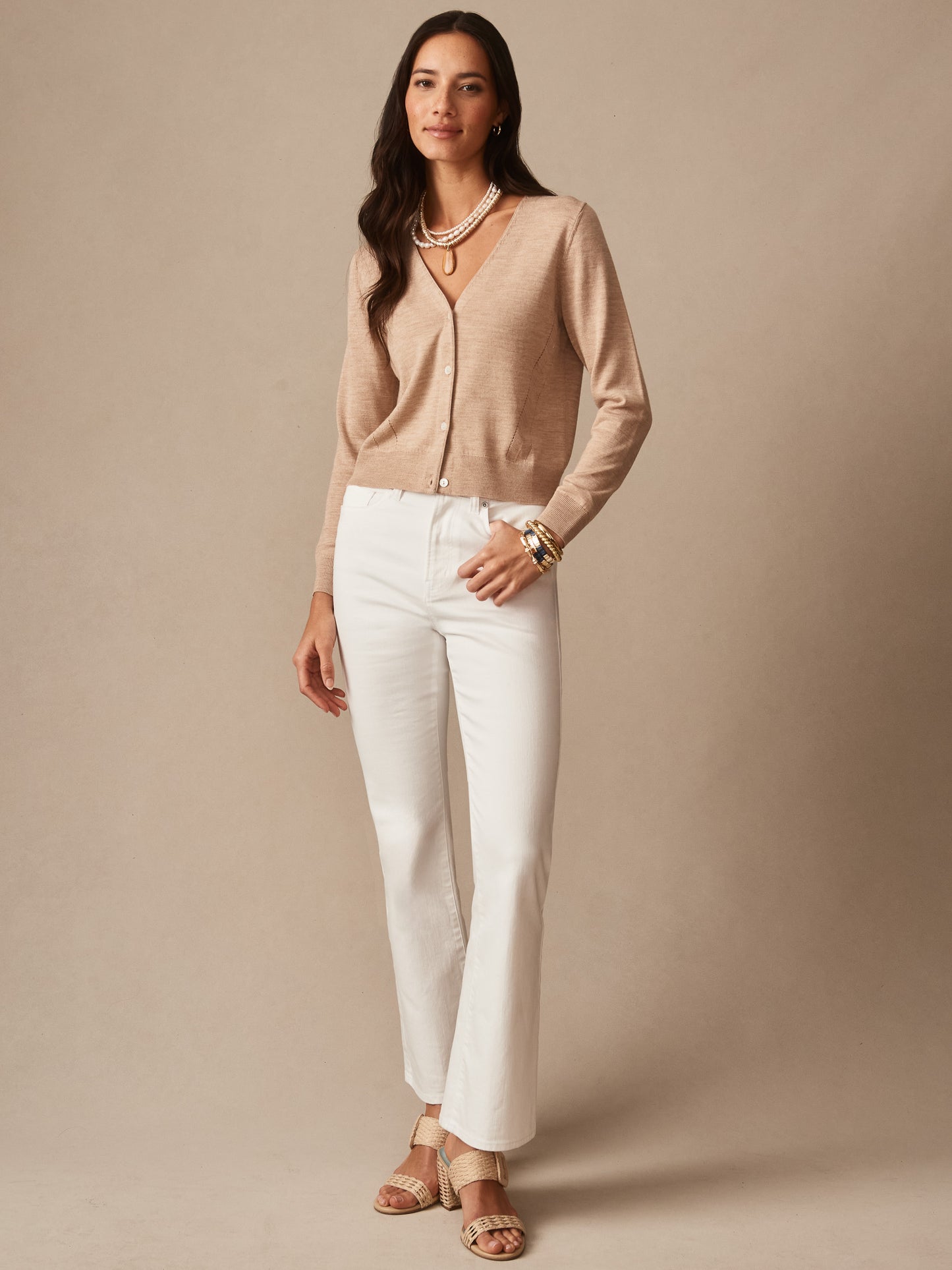 Woman wearing a beige Olivette Cardigan by J.McLaughlin with white pants and layered necklaces, styled for a timeless and elegant casual look.