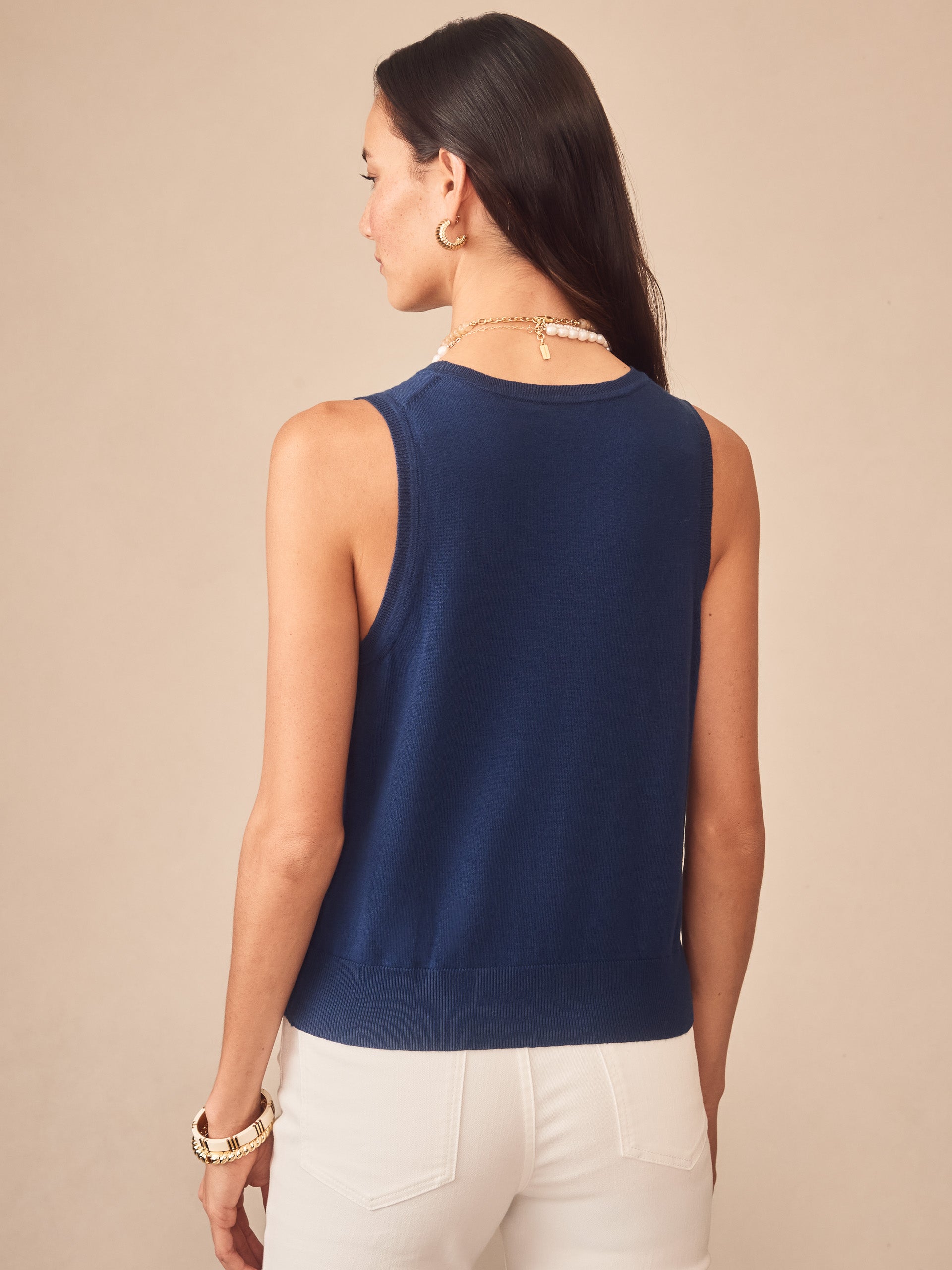 Woman wearing a nautical navy Opal Sweater Tank by J.McLaughlin, showcasing effortlessly stylish and enduring designs perfect for a legacy of timeless fashion. A destination for defining style. Life, Well-Lived.