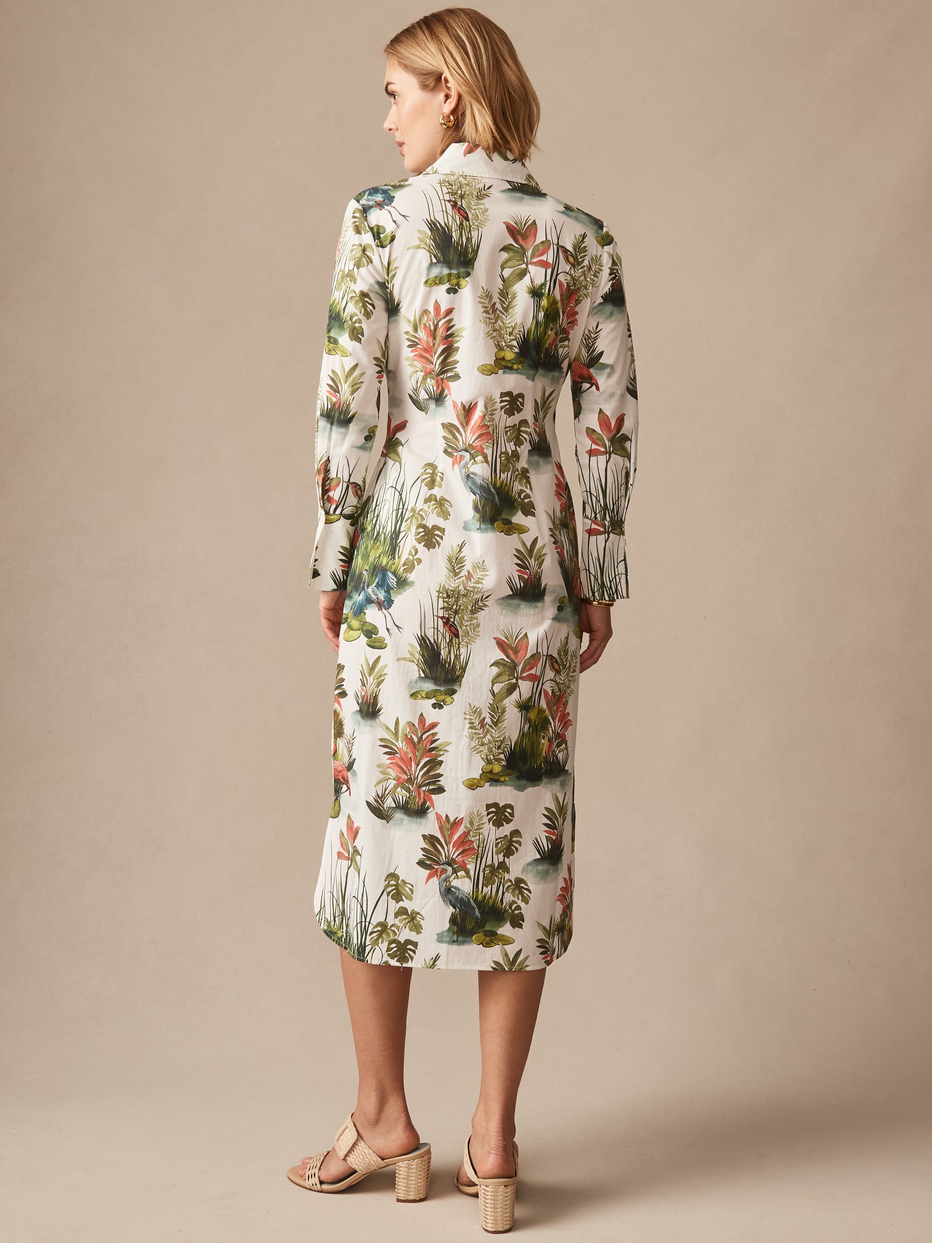 Woman modeling the Orla Dress in Tidal Palms by J.McLaughlin, featuring a floral print with green, coral, and white shades, embodying effortlessly stylish, enduring designs. A destination for defining style. Life, Well-Lived.