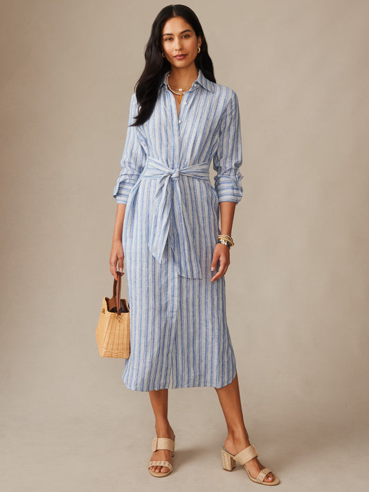 Woman wearing Orla Linen Dress in Stripe by J.McLaughlin, styled with a woven handbag and neutral sandals, showcasing effortlessly stylish, enduring designs with a legacy of timeless fashion. A destination for defining style. Life, Well-Lived.