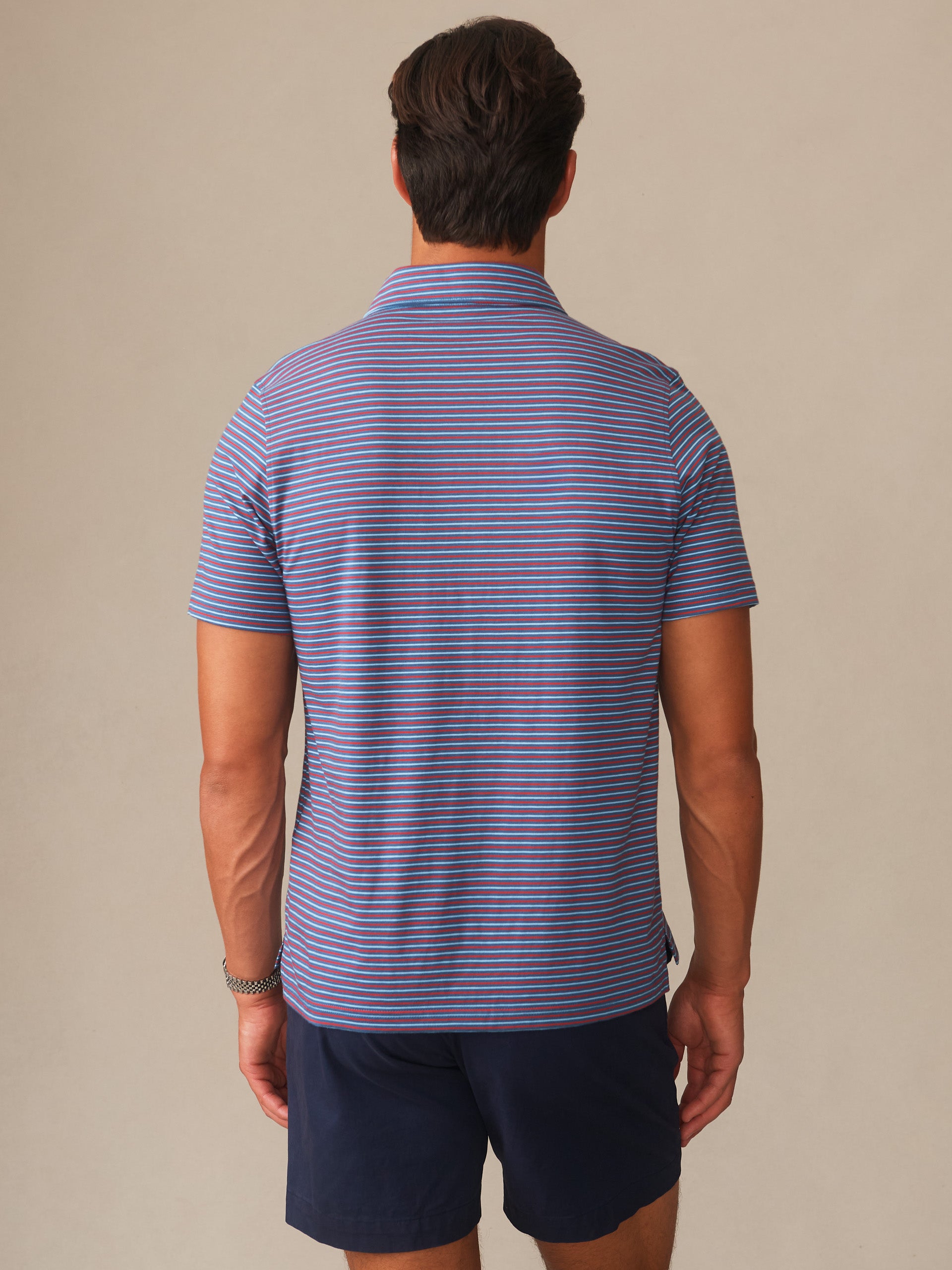 Man wearing Owens Polo in Multi Stripe Tricolor by J.McLaughlin, showcasing effortlessly stylish design with enduring appeal in a classic striped shirt, a destination for defining style. Life, Well-Lived.