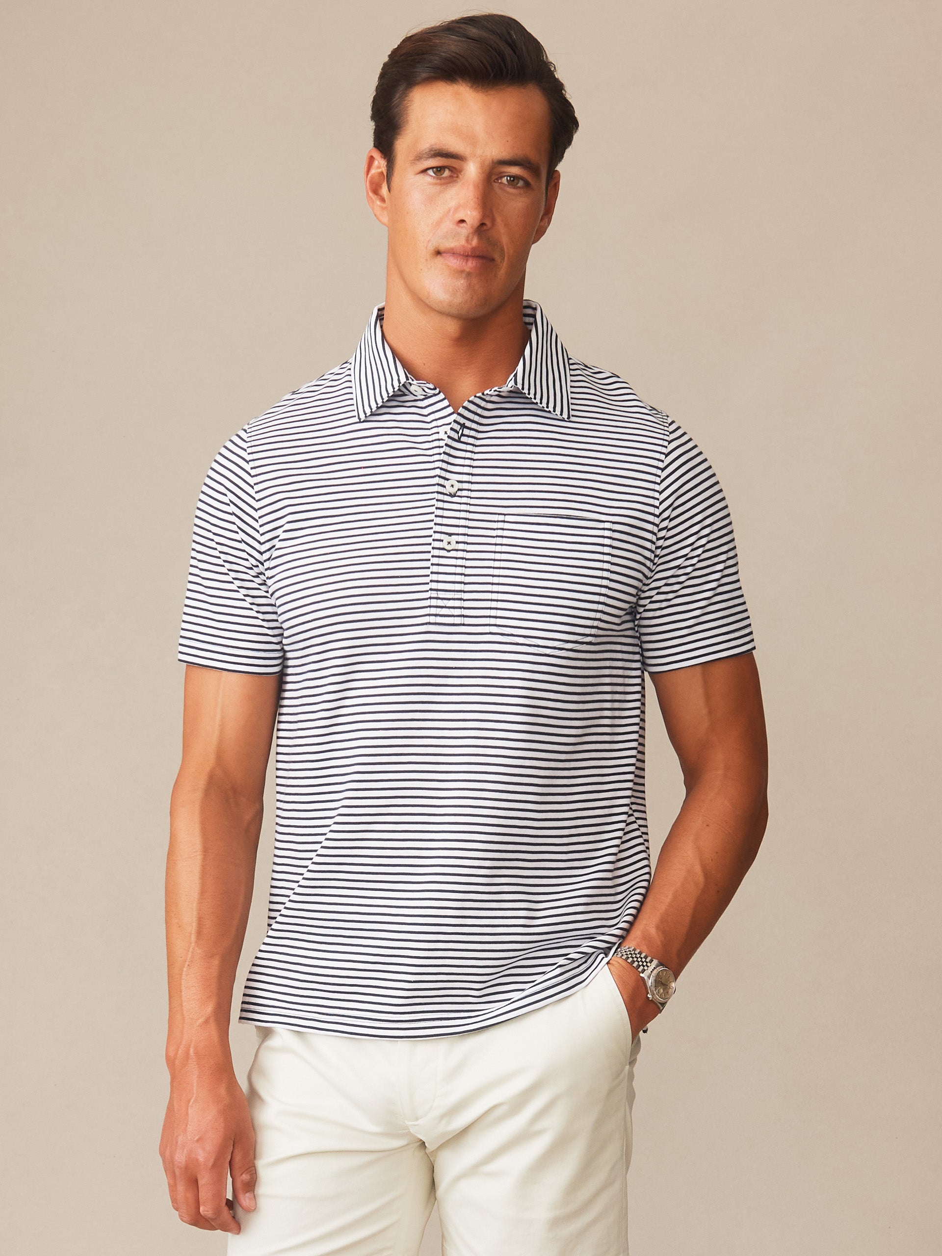 A man wearing the Owens Polo in Feeder Stripe by J.McLaughlin, featuring navy and white stripes, showcasing effortlessly stylish, enduring designs with innovative fabrics—A destination for defining style. Life, Well-Lived.