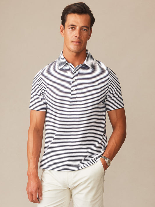 A man wearing the Owens Polo in Feeder Stripe by J.McLaughlin, featuring navy and white stripes, showcasing effortlessly stylish, enduring designs with innovative fabrics—A destination for defining style. Life, Well-Lived.