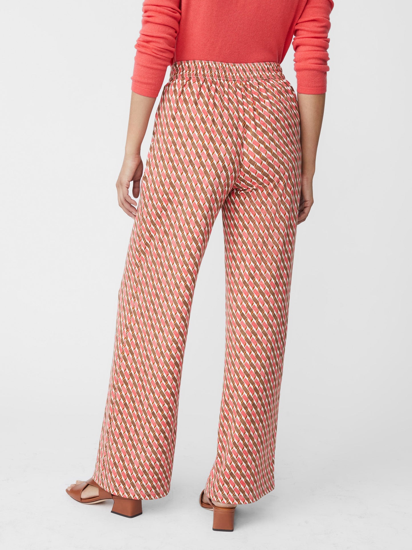 Model wears J.McLaughlin Pasha pants in coral/brown made with polyester/spandex.