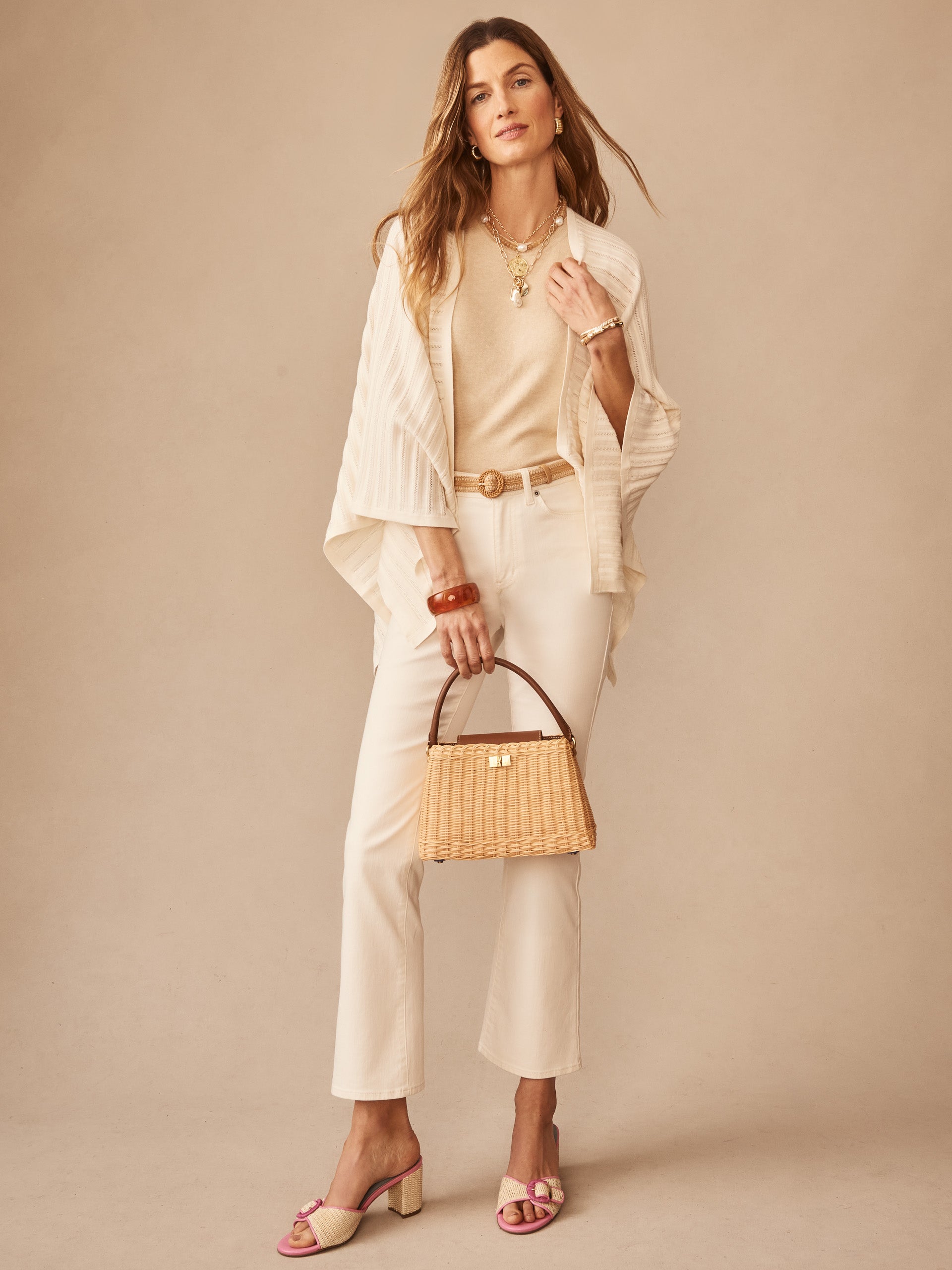Woman wearing neutral-toned outfit featuring a Penny Wrap bag by J.McLaughlin, showcasing effortlessly stylish, enduring designs with innovative fabrics in a legacy of timeless fashion. A destination for defining style. Life, Well-Lived.