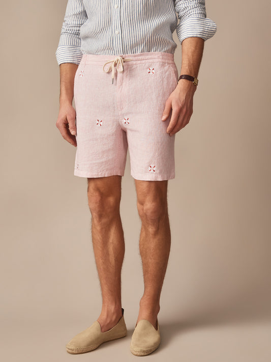 Man wearing Newport Linen Shorts in Lifesaver by J.McLaughlin, styled with a striped shirt and espadrilles, showcasing effortlessly stylish shorts with enduring designs and innovative fabrics.