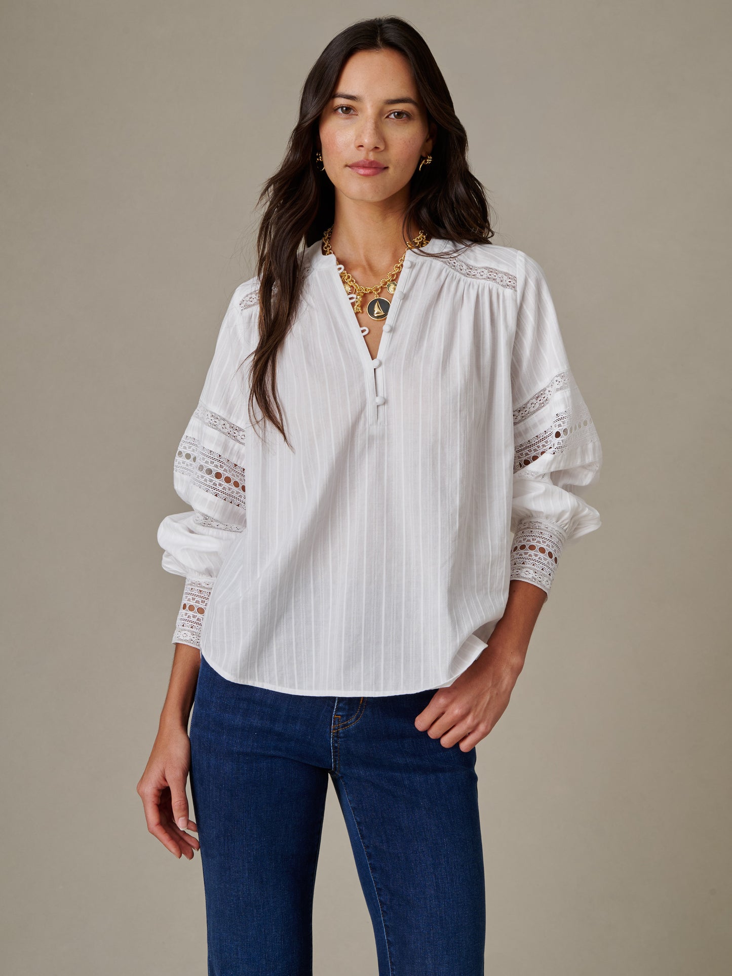 Woman wearing a white Posey Blouse by J.McLaughlin featuring delicate lace details on the sleeves, combining effortless style with timeless elegance.