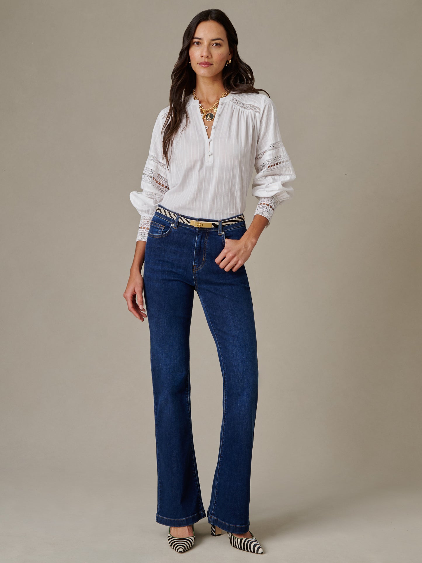 Woman wearing a Posey Blouse by J.McLaughlin, paired with dark blue jeans and striped pointed shoes, showcasing an effortlessly stylish, timeless look.