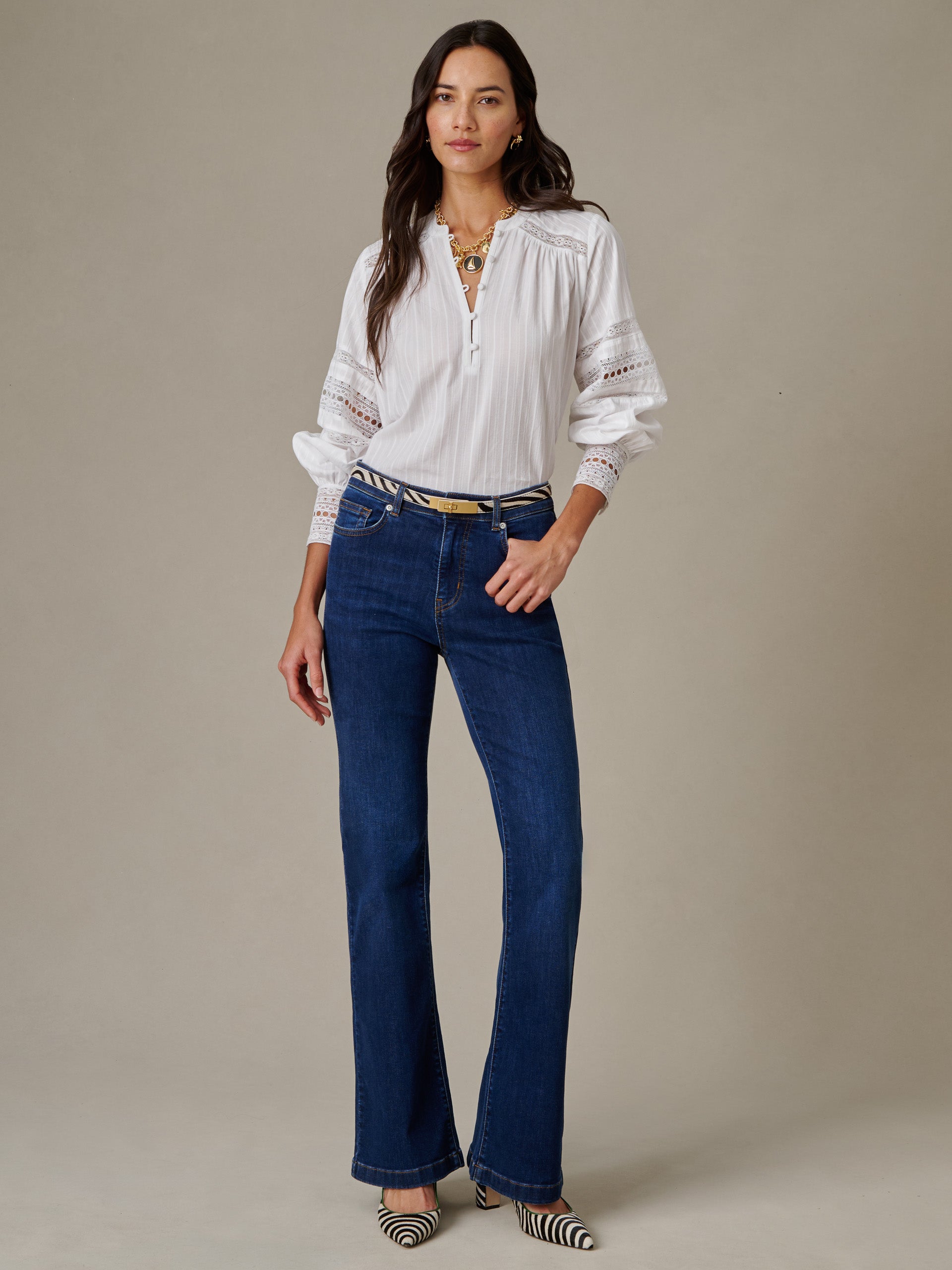 Woman wearing a Posey Blouse by J.McLaughlin, paired with dark blue jeans and striped pointed shoes, showcasing an effortlessly stylish, timeless look.