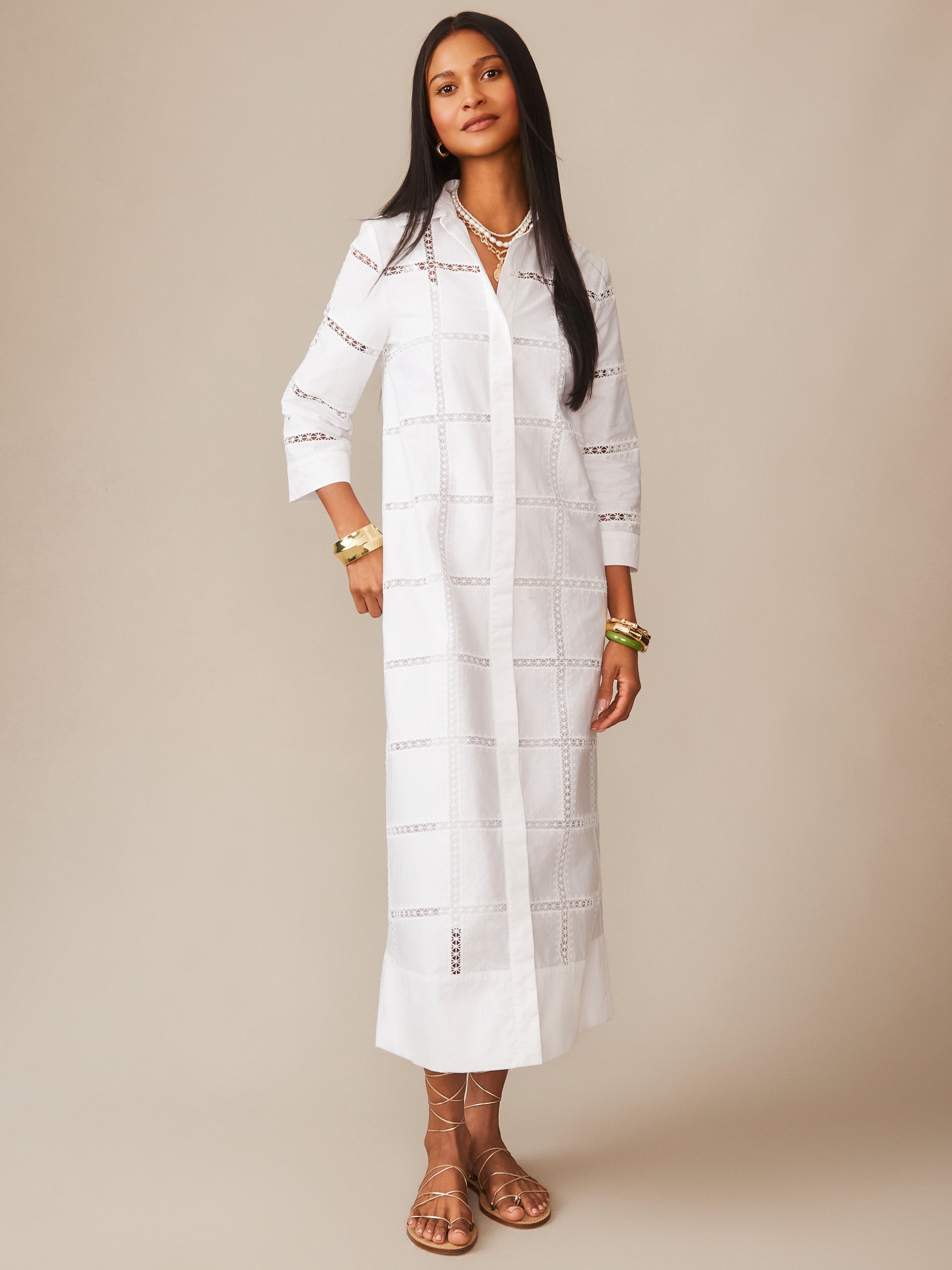 A model wearing the Rachel Embroidered Dress by J.McLaughlin, a white, airy dress with intricate embroidery and airy cutouts, embodying effortlessly stylish, enduring designs with a legacy of timeless fashion. A destination for defining style. Life, Well-Lived.
