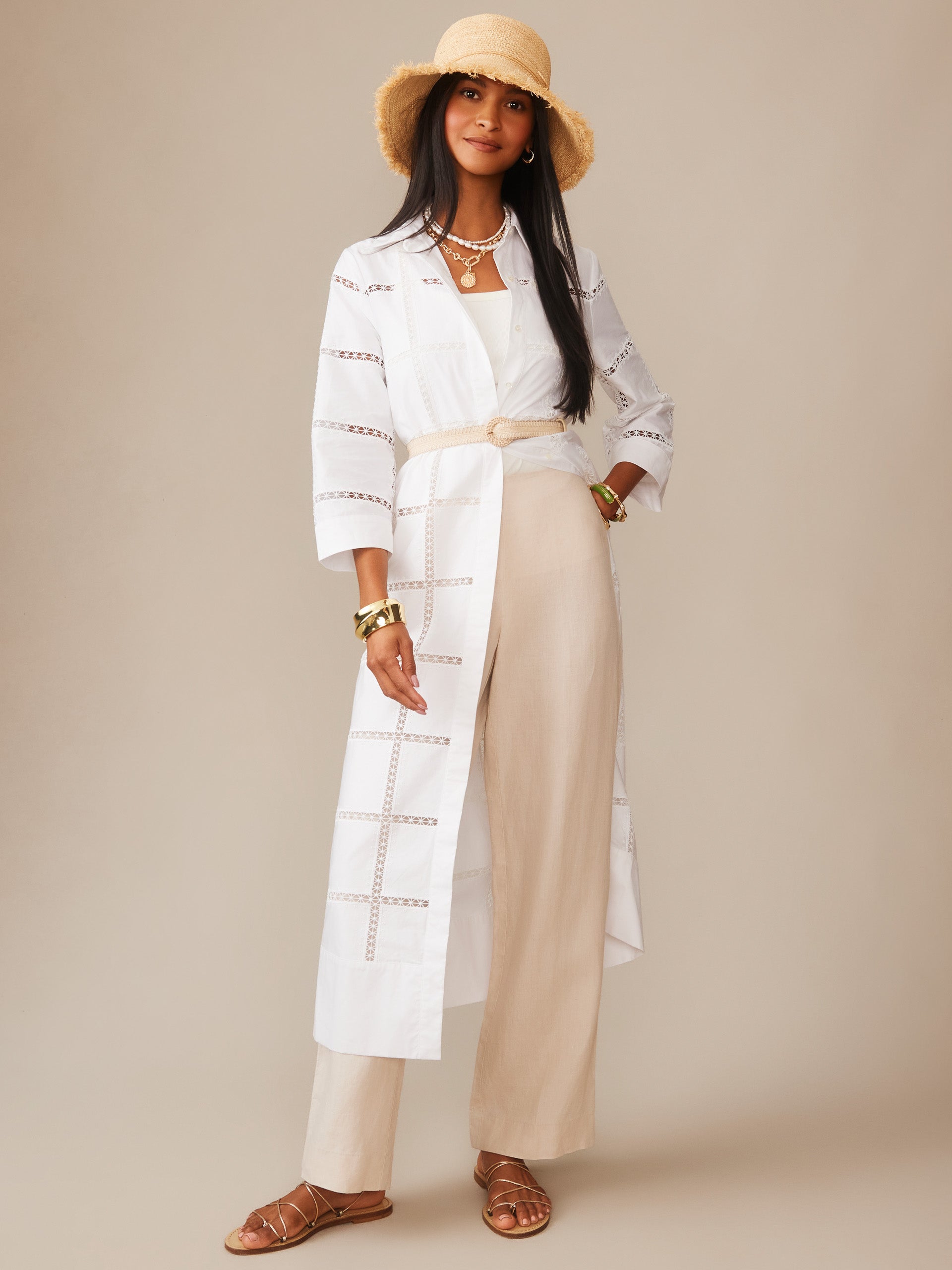 Woman wearing the Rachel Embroidered Dress by J.McLaughlin, styled with beige wide-leg pants, layered gold jewelry, a beige hat, and strappy sandals, showcasing effortlessly stylish, enduring designs in innovative fabrics from a destination for defining style. Life, Well-Lived.