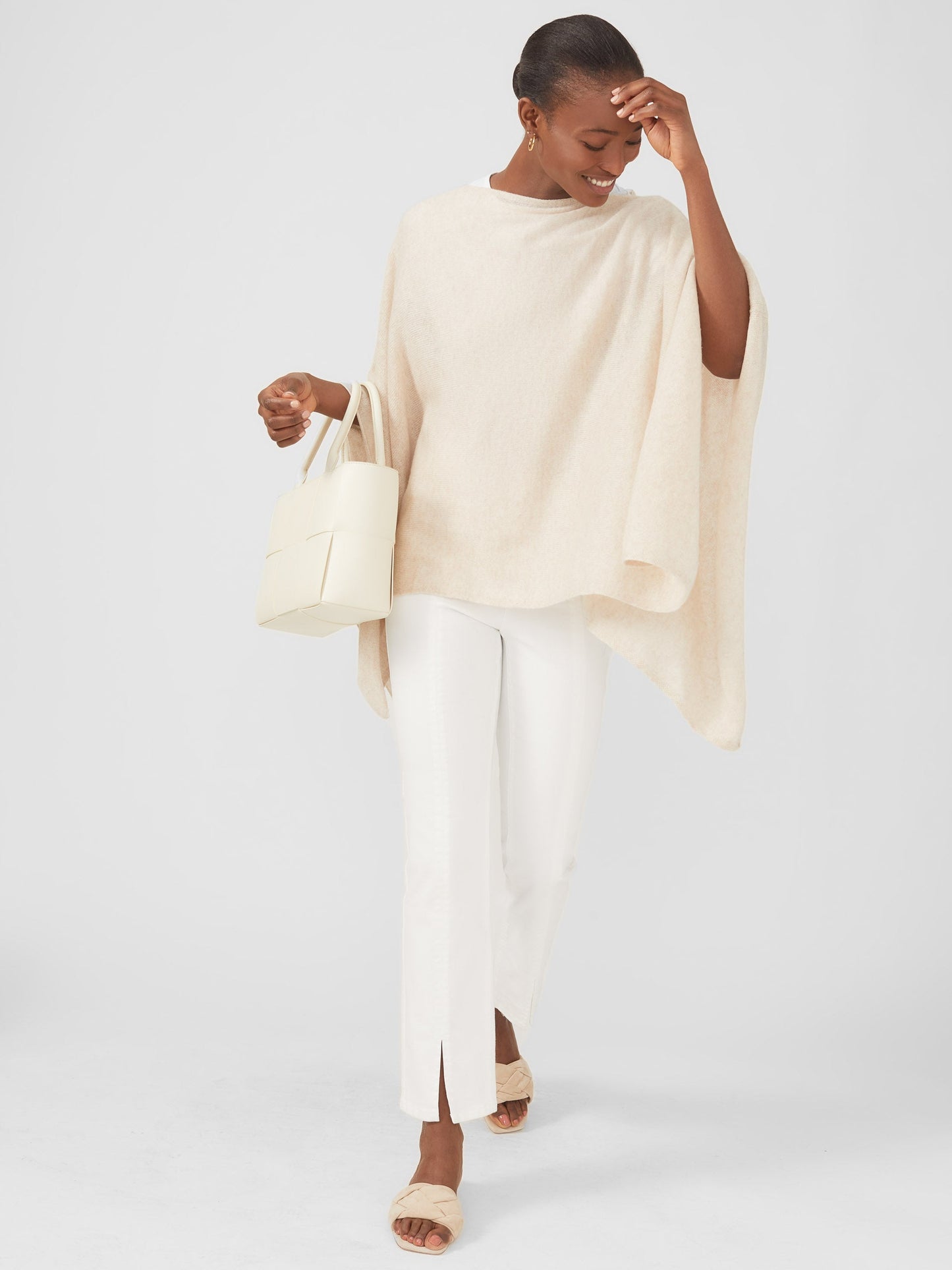 Model wearing J.McLaughlin Rale poncho in light heather oatmeal made with cashmere.