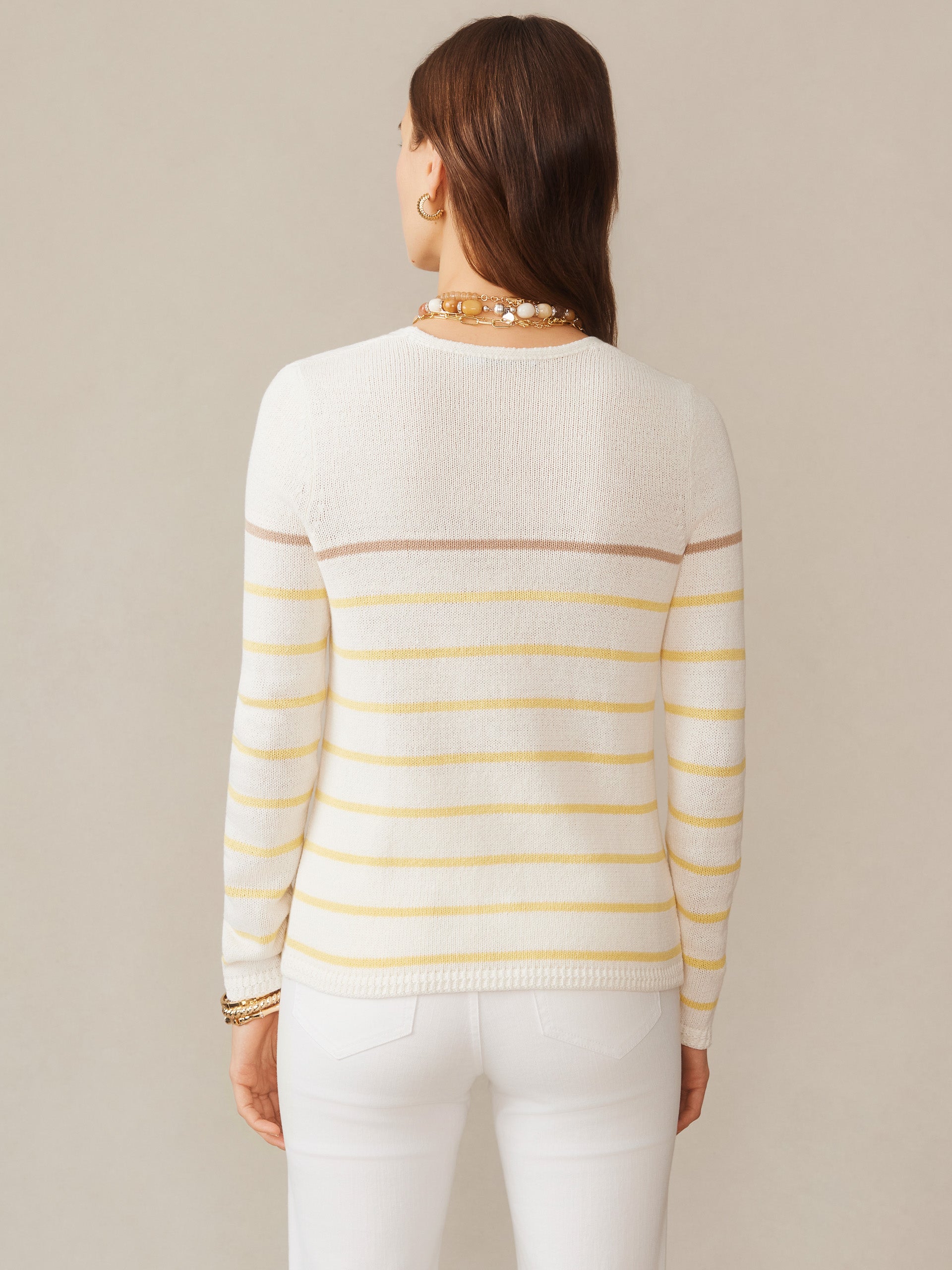 Back view of a woman wearing the Ramona Linen Blend Sweater in Stripe by J.McLaughlin, featuring soft yellow and neutral stripes, showcasing effortlessly stylish, enduring designs with innovative fabrics, reflecting a legacy of timeless fashion. A destination for defining style. Life, Well-Lived.