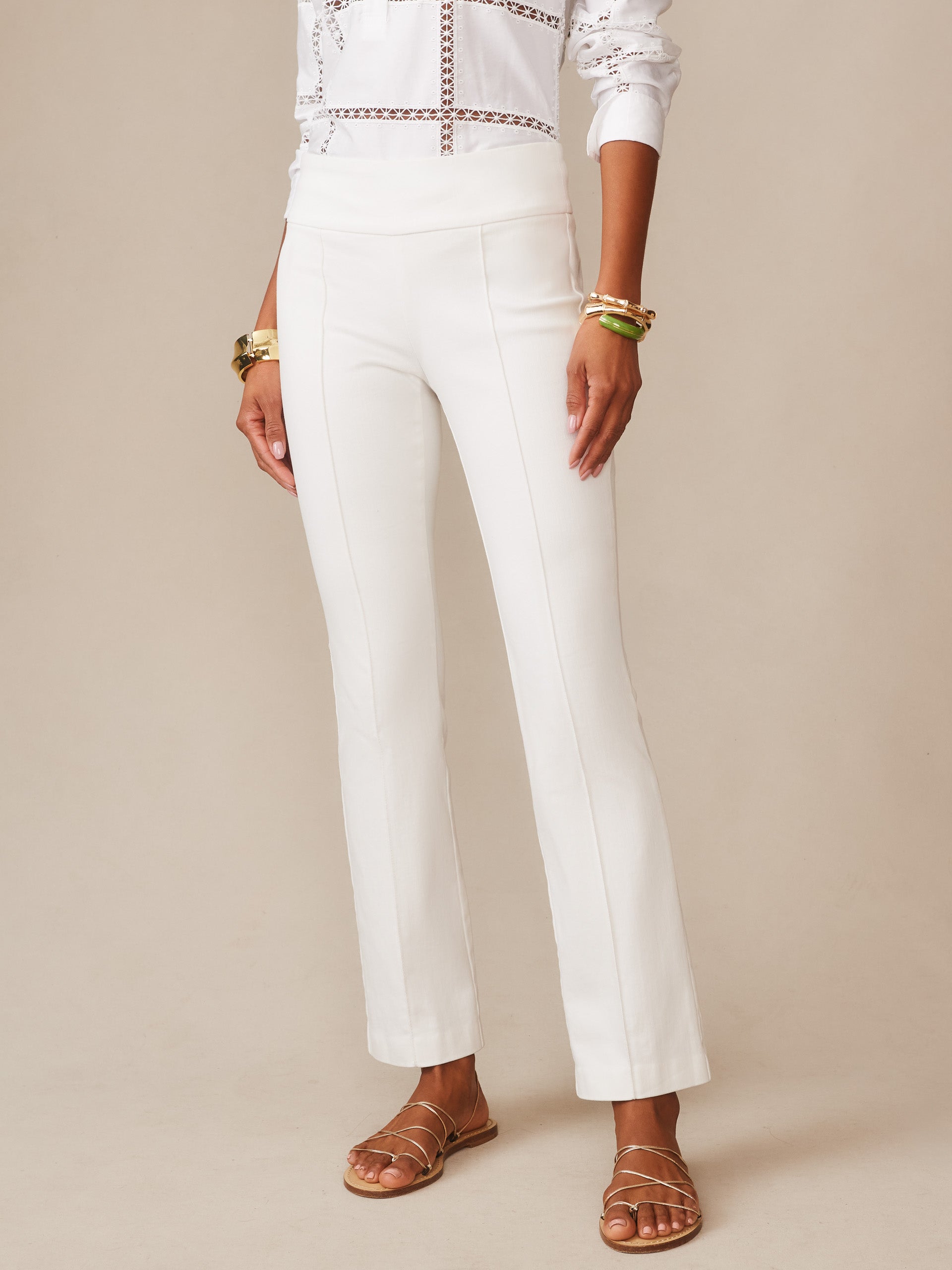 Model wearing white Rylie Jeans by J.McLaughlin, styled with a classic blouse and gold bracelets, showcasing effortlessly stylish, enduring designs and innovative fabrics.