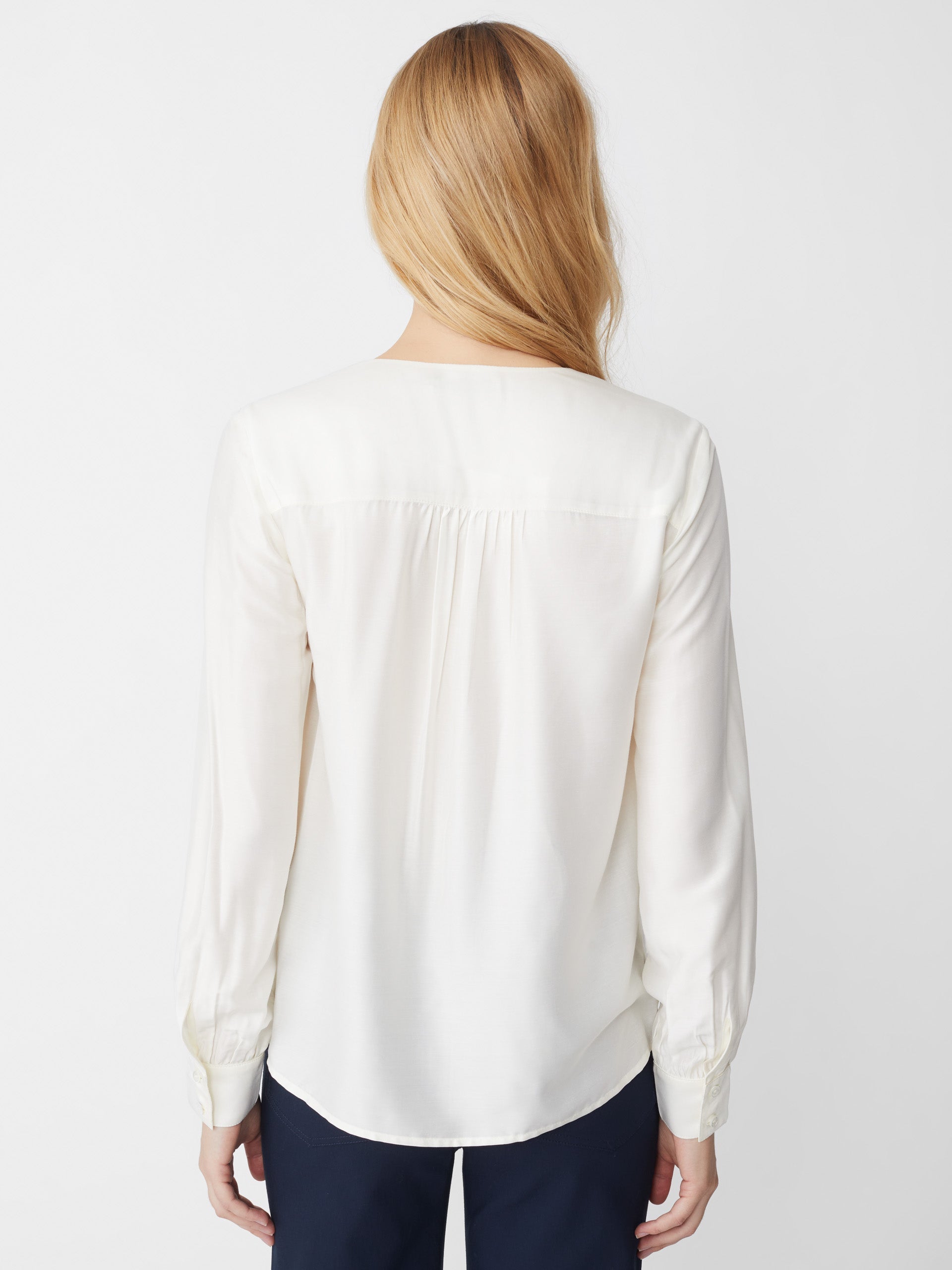 Model wears J.McLaughlin Rinaldo blouse in off white made with silk/rayon.