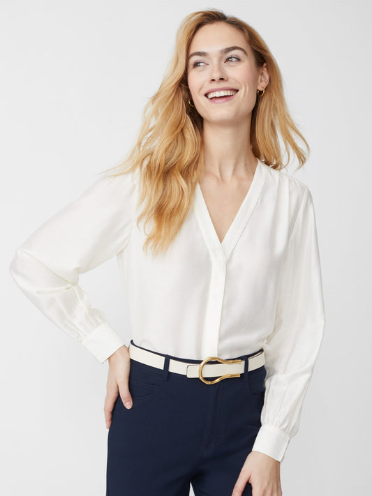 Model wears J.McLaughlin Rinaldo blouse in off white made with silk/rayon.