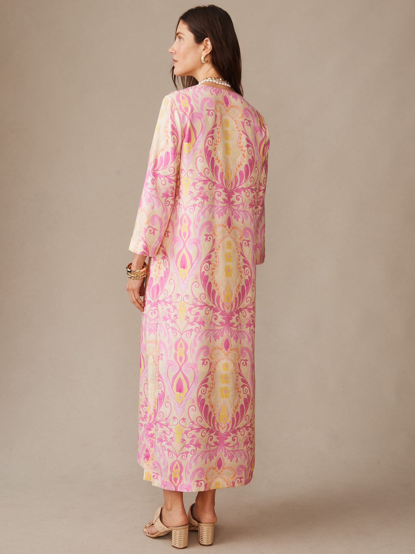 A woman wearing the Roni Silk Blend Dress in Midi Deco Bloom by J.McLaughlin, featuring an effortlessly stylish, flowing midi-length dress in soft pink and cream paisley patterns that embodies enduring designs and innovative fabrics. A destination for defining style. Life, Well-Lived.
