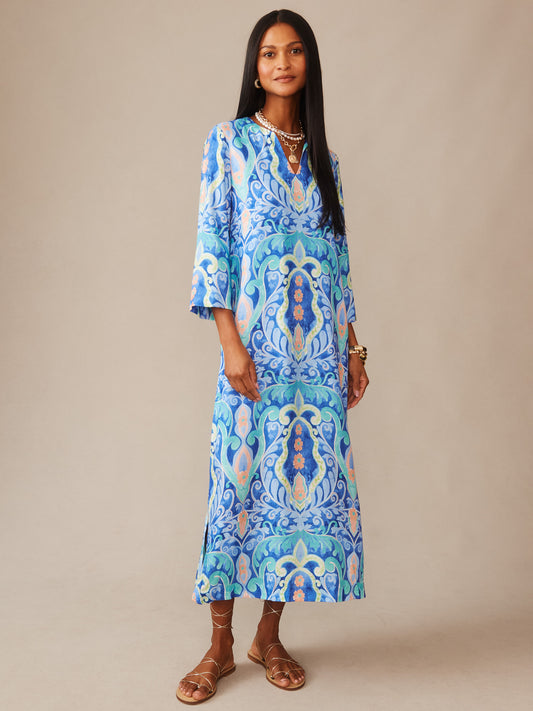 A model wearing the Roni Silk Blend Dress in Midi Deco Bloom by J.McLaughlin, featuring a vibrant blue and aqua pattern with effortless style and enduring design, perfect for a life well-lived.