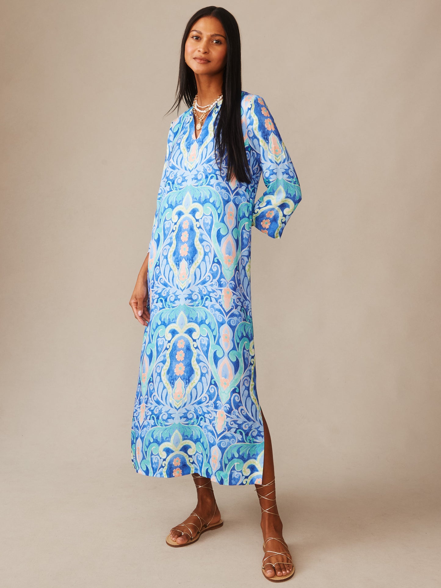 A model wears the Roni Silk Blend Dress in Midi Deco Bloom by J.McLaughlin, featuring an effortlessly stylish blue and aqua pattern that highlights innovative fabrics and enduring designs.