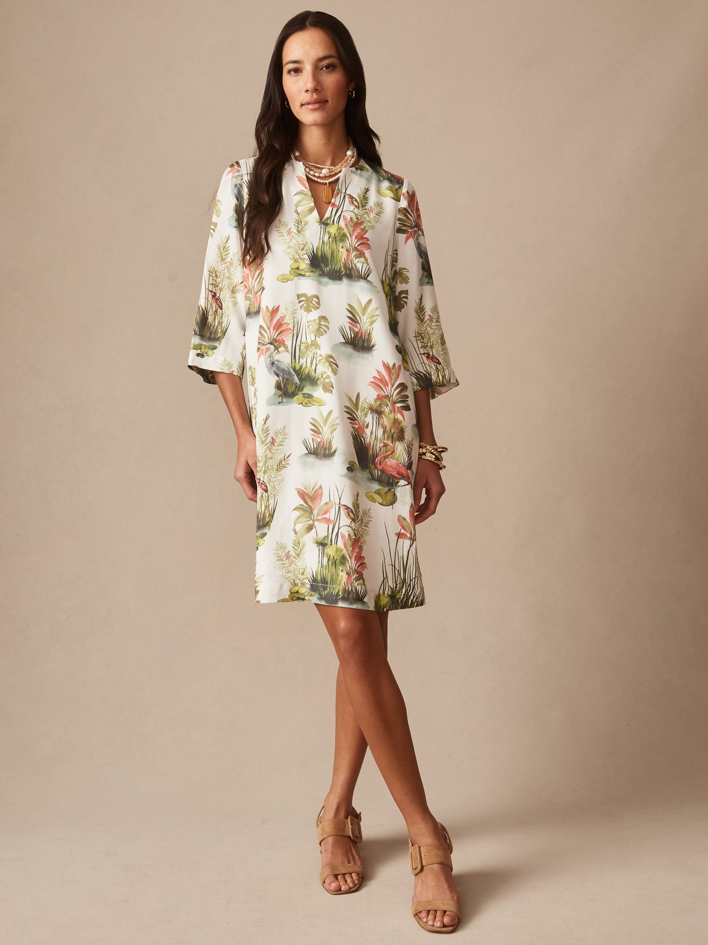 Woman wearing a Roni Dress in Tidal Palms by J.McLaughlin, featuring a classic white base with coral and green tropical prints, embodying effortlessly stylish, enduring designs and innovative fabrics. A destination for defining style. Life, Well-Lived.