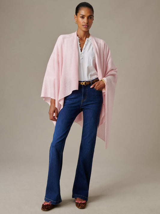 Woman wearing a soft pink Rossi Cashmere Wrap layered over a white blouse and dark blue jeans with leopard print shoes, showcasing J.McLaughlin's effortlessly stylish, enduring design.
