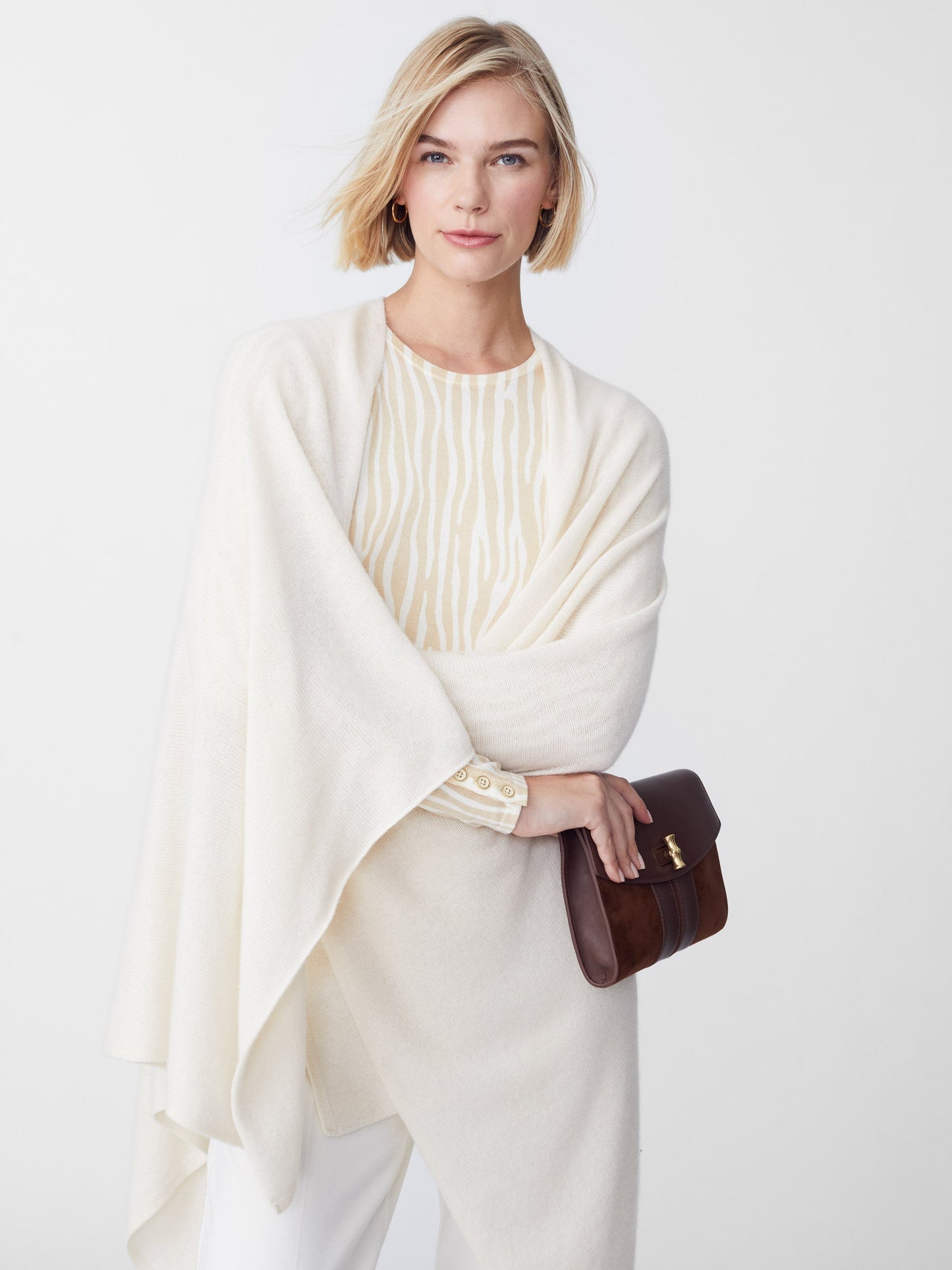 Model wearing J.McLaughlin Rossi wrap in off white made with cashmere.