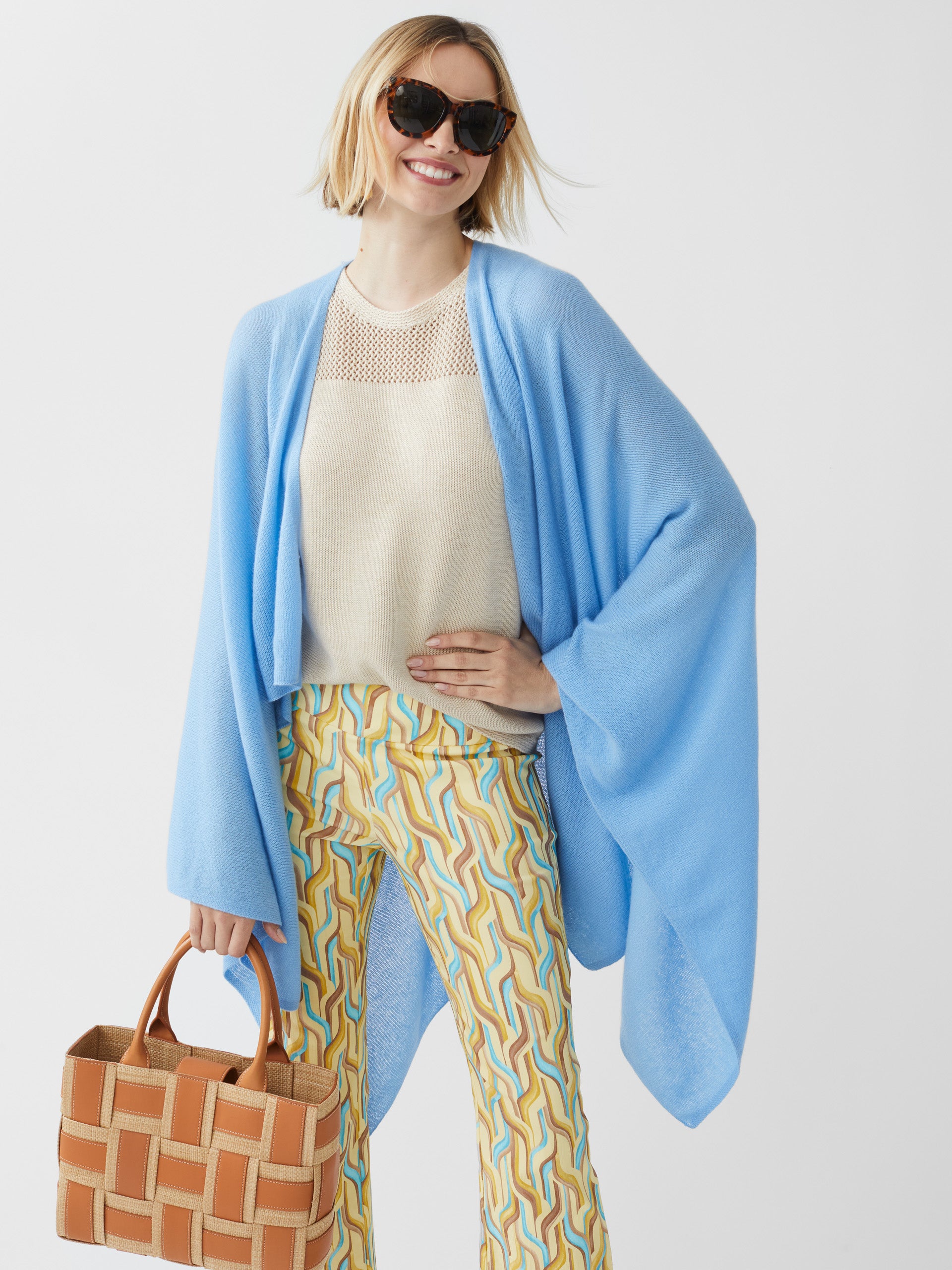 Model wearing J.McLaughlin Rossi wrap in light blue made with cashmere.