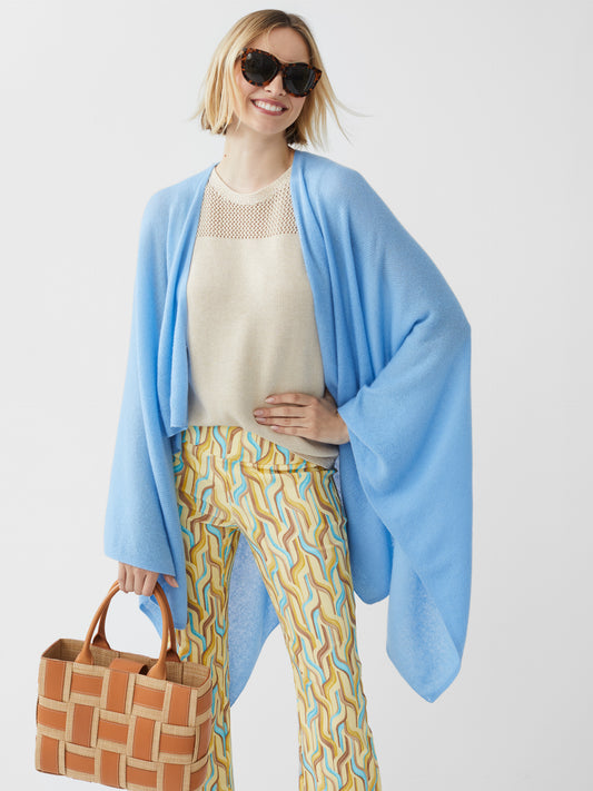 Model wearing J.McLaughlin Rossi wrap in light blue made with cashmere.