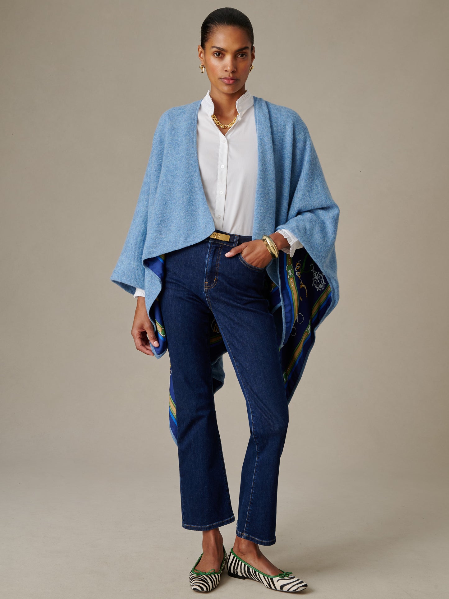 Elegant woman wearing a Rossi Cashmere Wrap in Fairfax Crest by J.McLaughlin over a white blouse and dark jeans, showcasing timeless style with lasting comfort and quality craftsmanship.