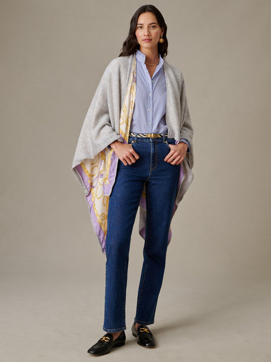 Woman wearing a light blue shirt and dark jeans styled with the Rossi Cashmere Wrap in Grand Heraldic Border by J.McLaughlin, showcasing effortless, timeless style.