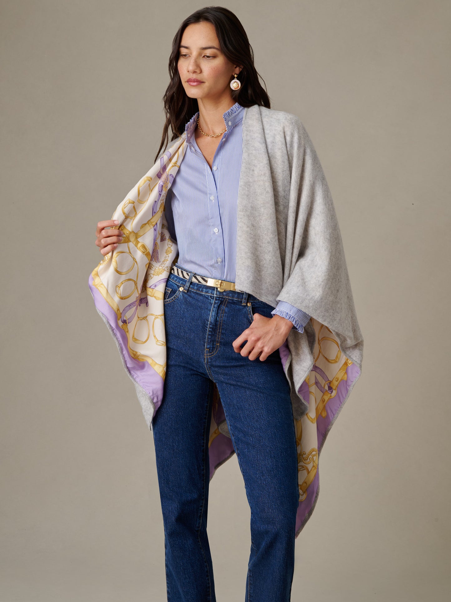 Woman wearing a Rossi Cashmere Wrap in Grand Heraldic Border by J.McLaughlin, styled over a blue blouse and jeans, showcasing an effortlessly stylish and timeless look.