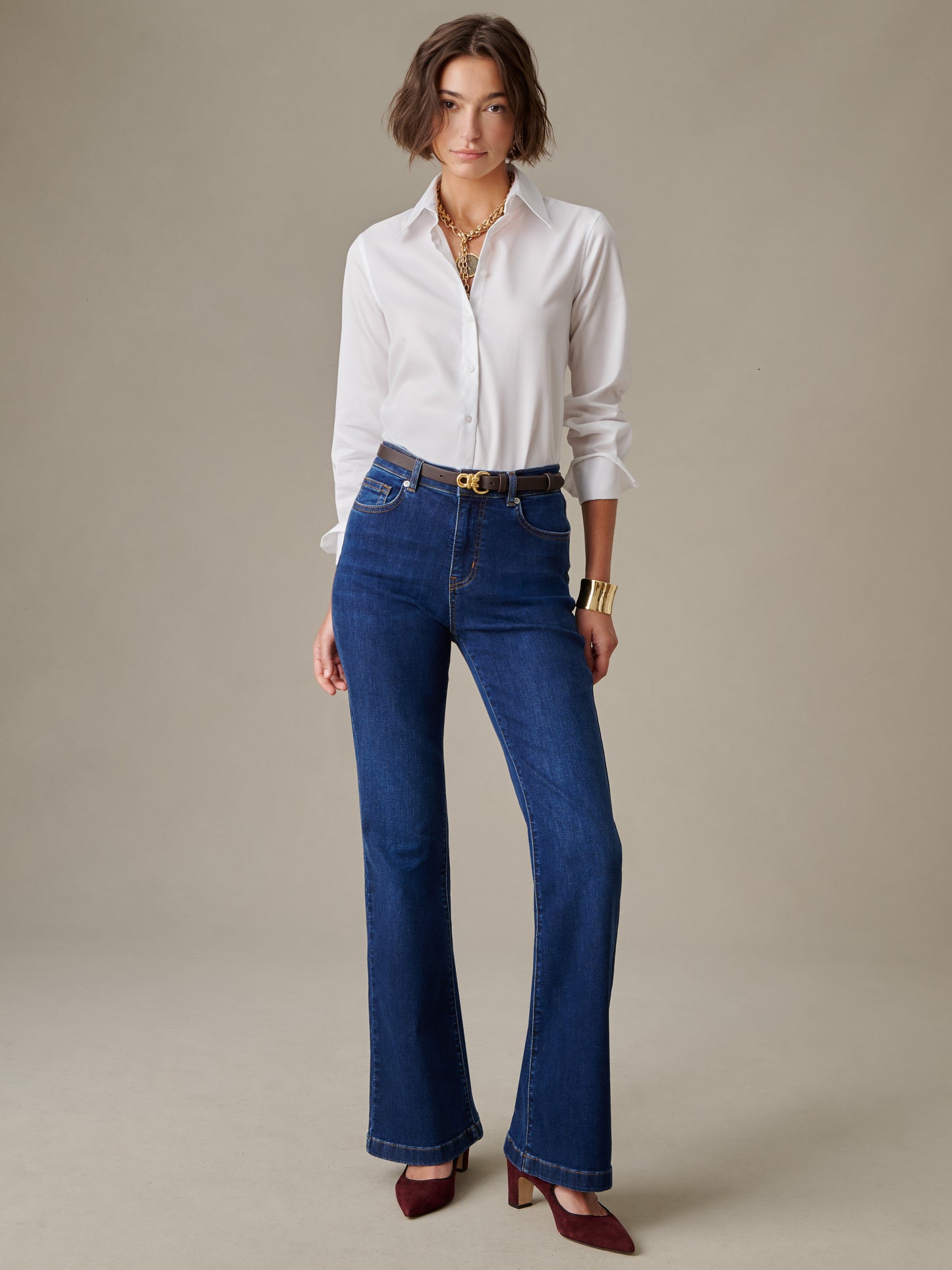 Woman wearing Domino Jeans by J.McLaughlin paired with a white blouse, styled with a belt and gold jewelry, showcasing timeless and effortlessly stylish classic denim.