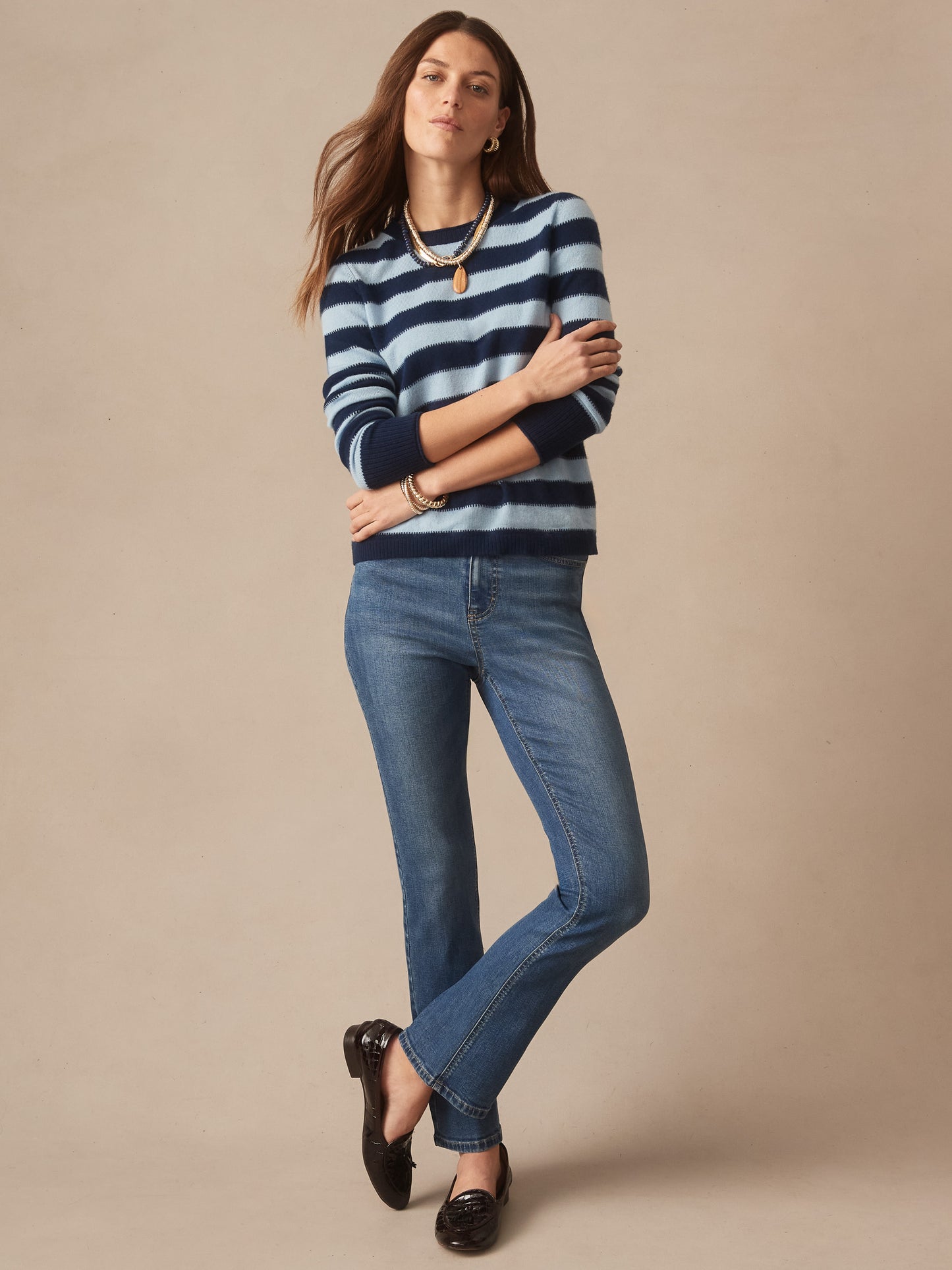 Woman wearing a Ruby Cashmere Sweater in Stripe by J.McLaughlin in navy and light blue paired with classic blue jeans and black loafers, showcasing effortlessly stylish, enduring designs and innovative fabrics from a destination for defining style. Life, Well-Lived.