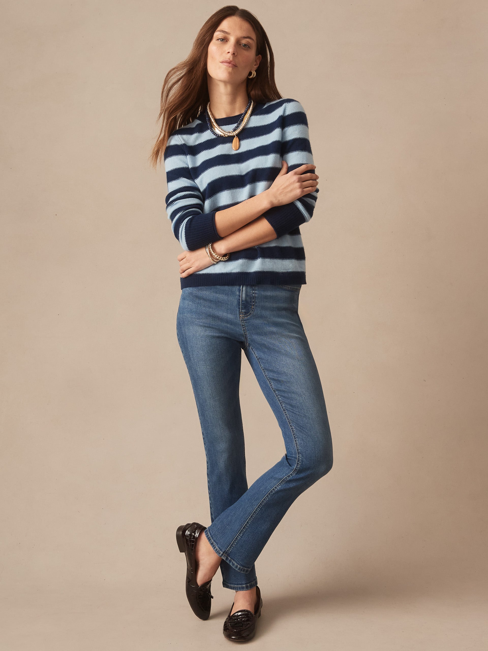 Woman wearing a Ruby Cashmere Sweater in Stripe by J.McLaughlin in navy and light blue paired with classic blue jeans and black loafers, showcasing effortlessly stylish, enduring designs and innovative fabrics from a destination for defining style. Life, Well-Lived.