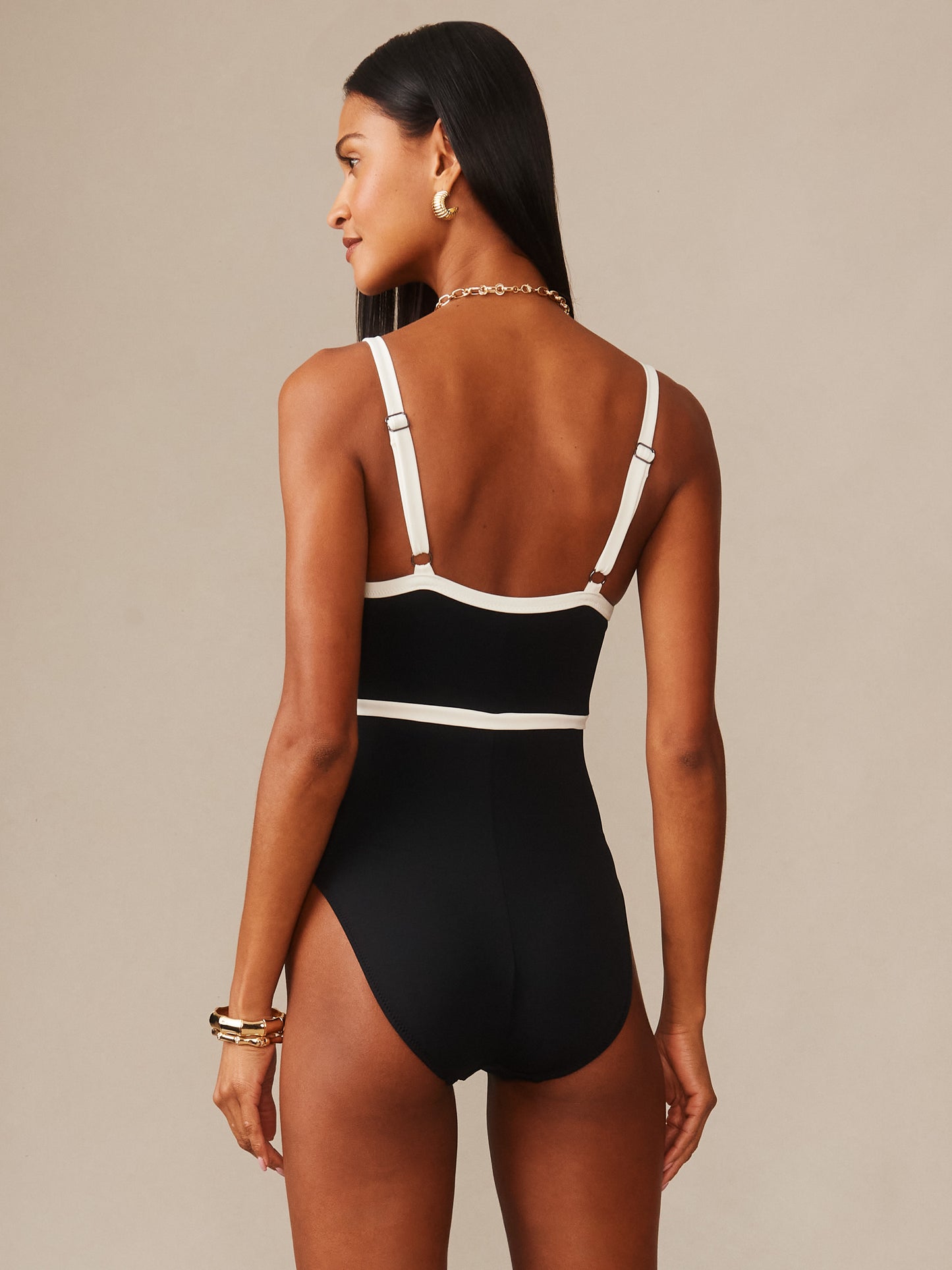 Model wearing the Sailor One Piece Swimsuit by J.McLaughlin, showcasing effortless style and enduring design with contrasting white trim and adjustable straps, embodying a legacy of timeless fashion.