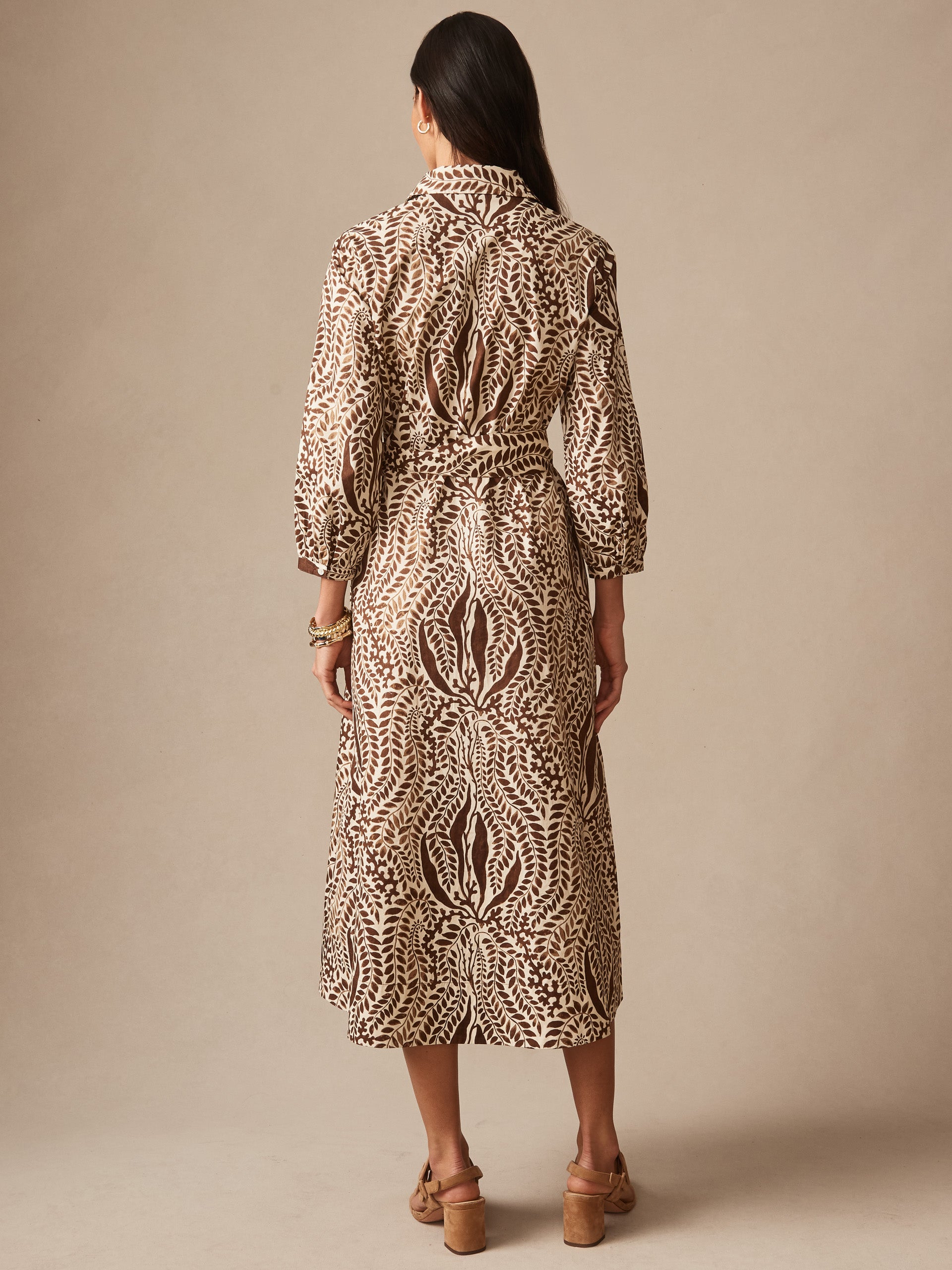 Woman wearing the Sena Dress in Coral Current by J.McLaughlin, showcasing an effortlessly stylish patterned mid-length dress with three-quarter sleeves, embodying enduring designs and a legacy of timeless fashion.