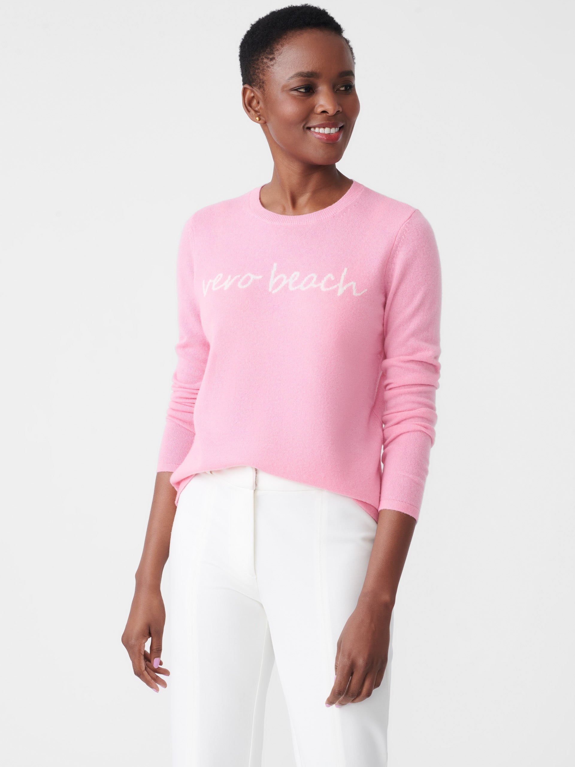 Model wearing J.McLaughlin Shield sweater in pink/white made with cashmere.