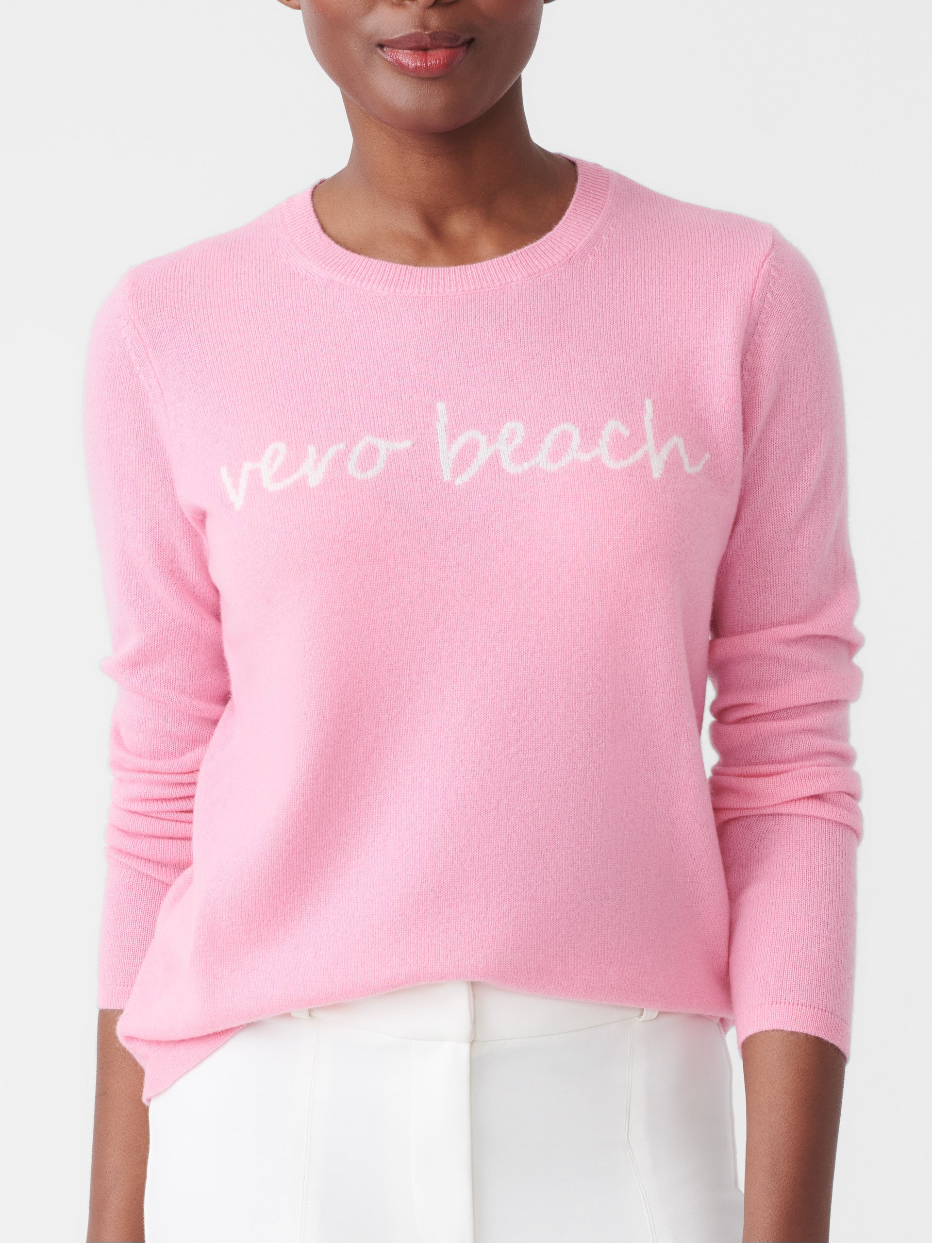 Model wearing J.McLaughlin Shield sweater in pink/white made with cashmere.