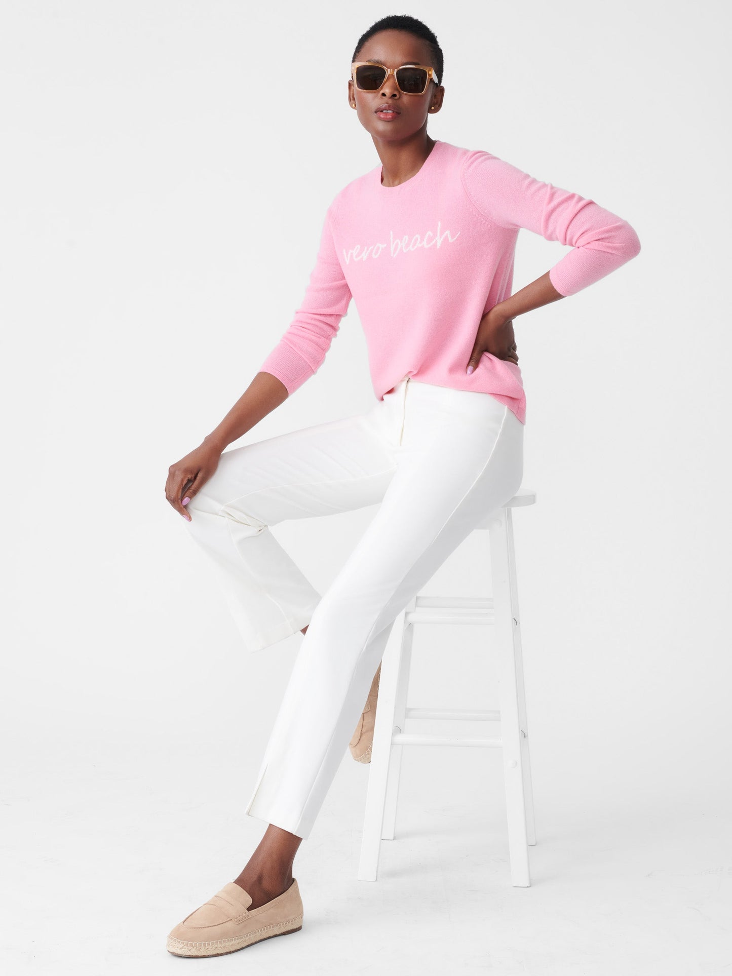 Model wearing J.McLaughlin Shield sweater in pink/white made with cashmere.