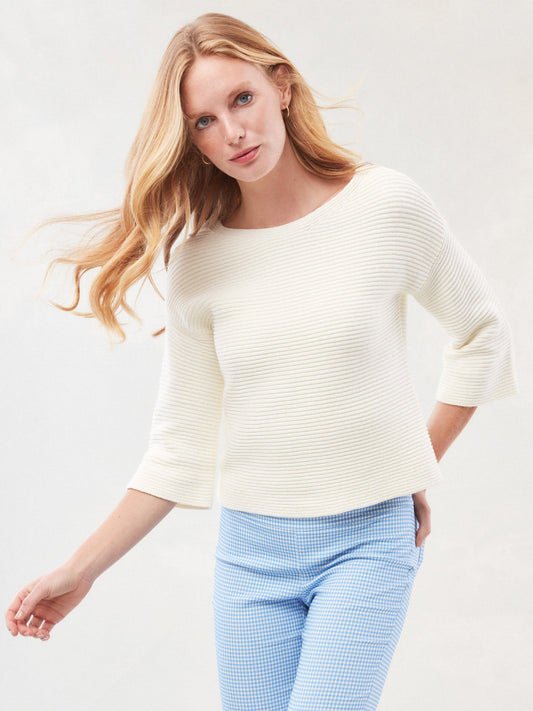 Model wearing J.McLaughlin Emmeline sweater in egret white made with cotton/nylon.