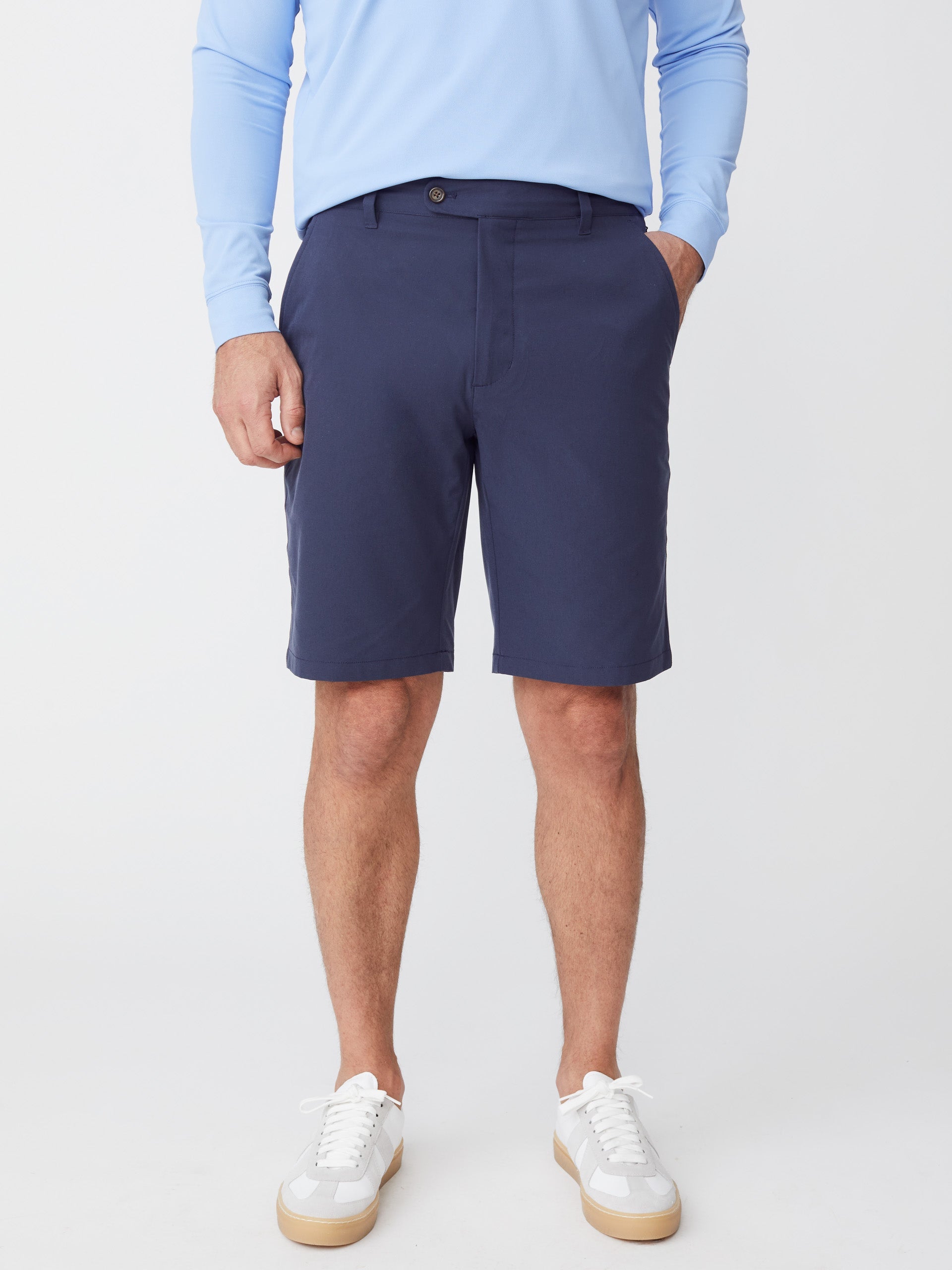 Model wearing J.McLaughlin Silas shorts in navy made with performance fabric.