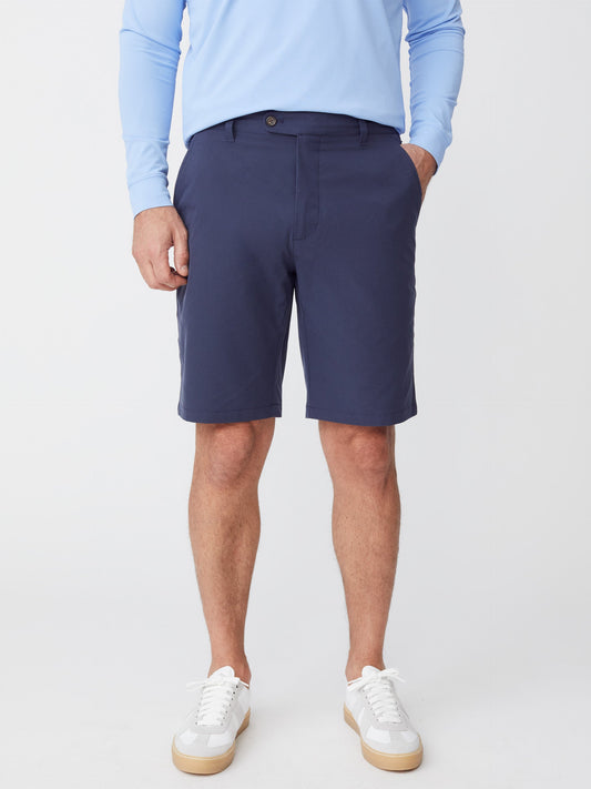 Model wearing J.McLaughlin Silas shorts in navy made with performance fabric.